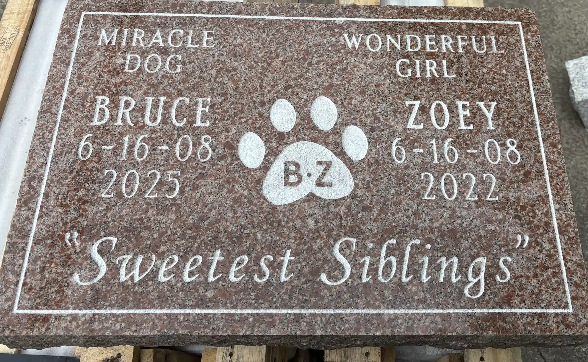 A granite headstone commemorating dog named Bruce and Zoey.