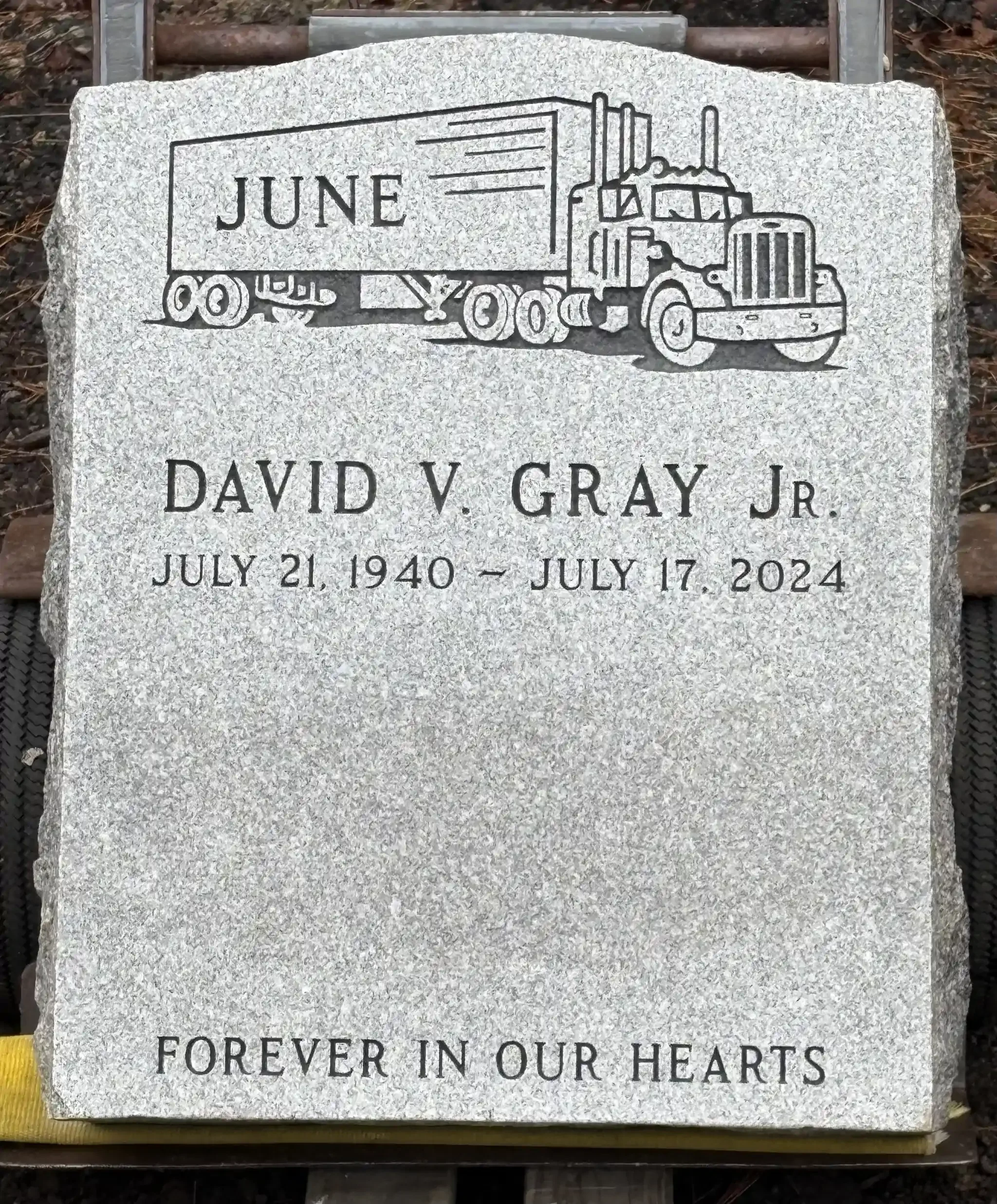 Gravestone with text inside a drawing of a moving truck.