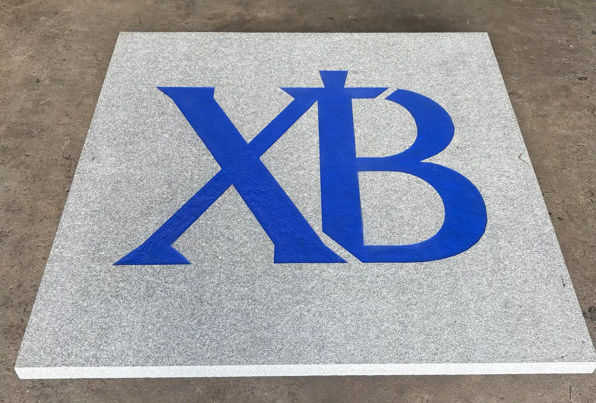 Blue Greek letters engraved into a stone surface.