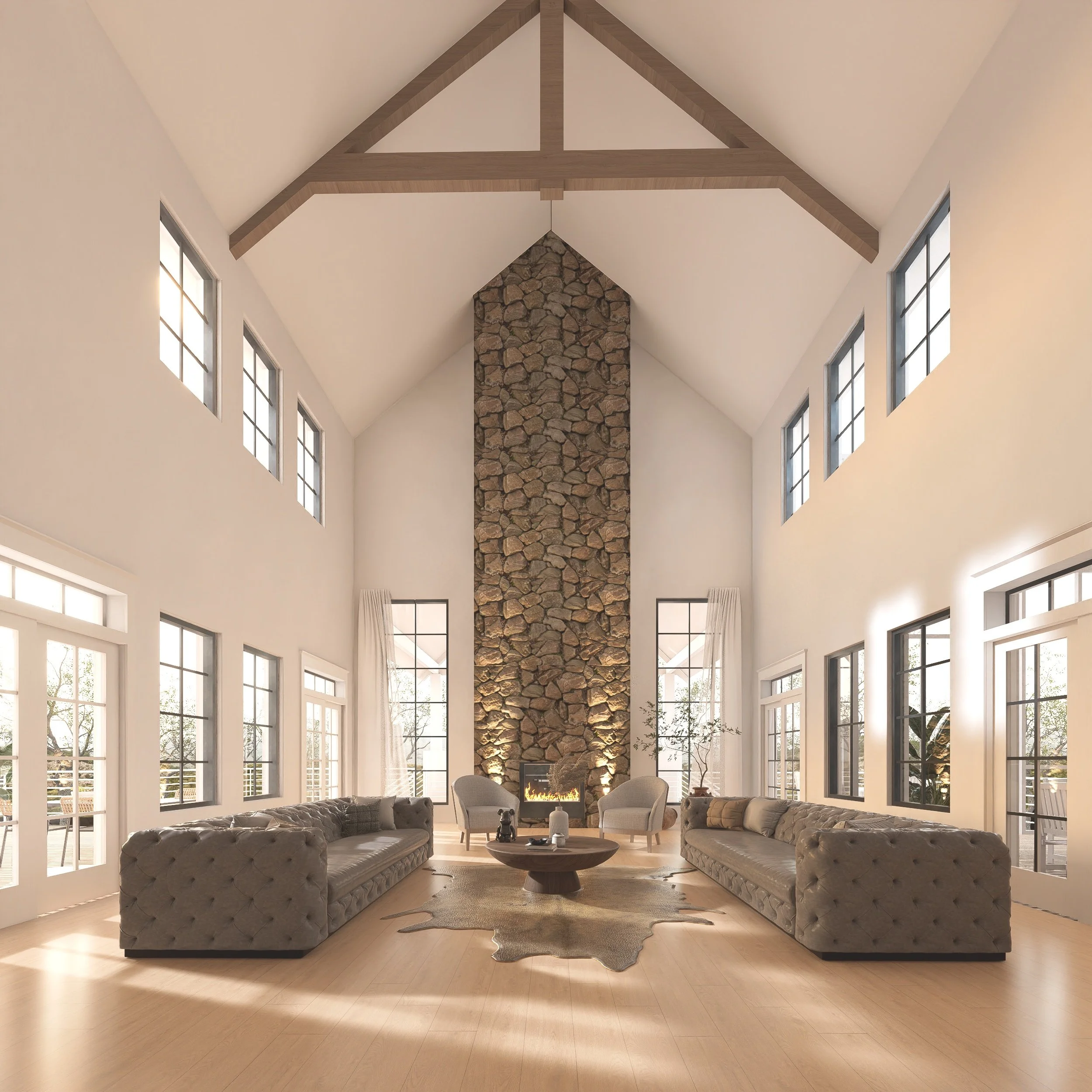 A spacious living room with high vaulted ceilings, large windows, a stone fireplace, and modern furniture including two long tufted sofas, two armchairs, and a round coffee table on a cowhide rug.