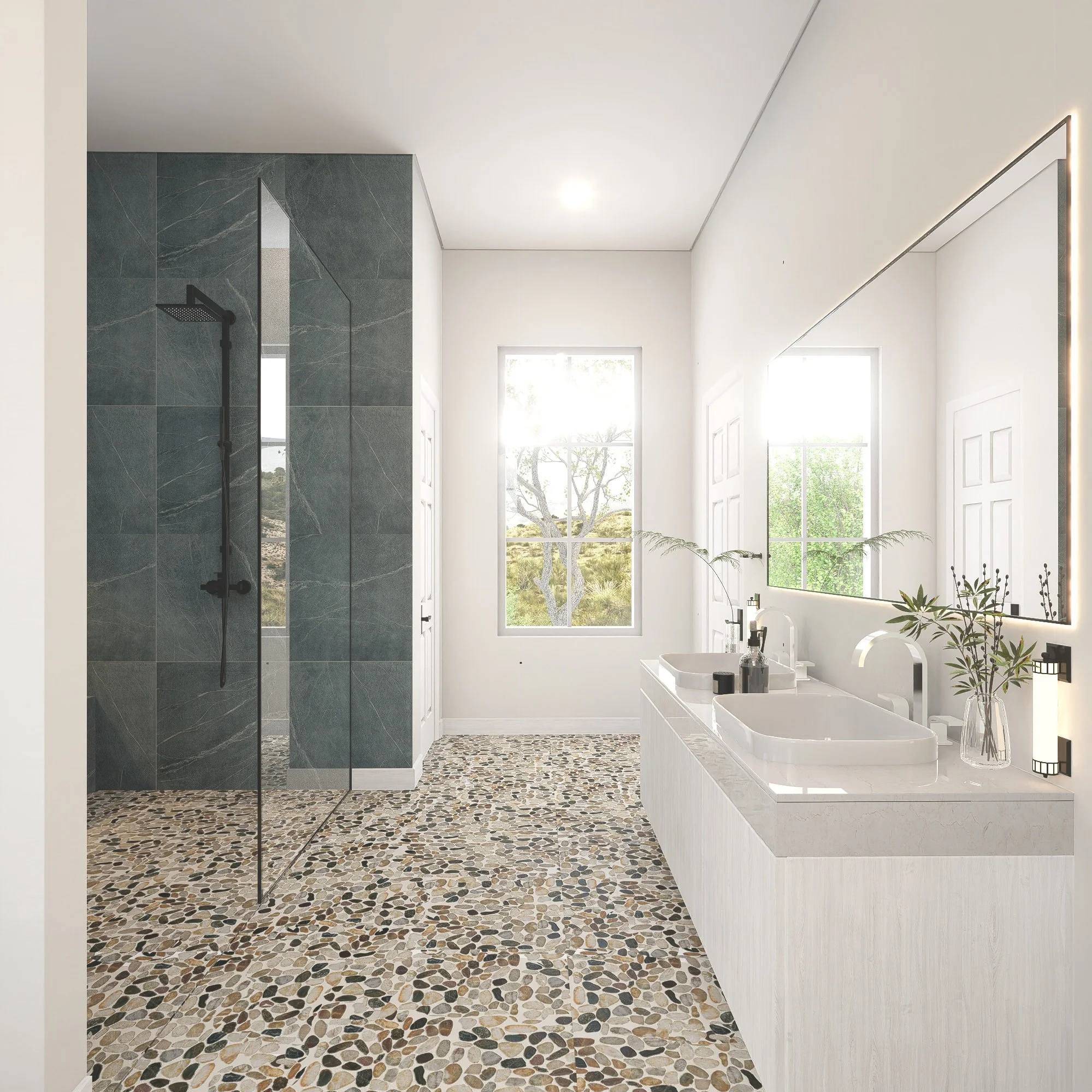 Modern bathroom with a pebble stone floor, white walls, a double sink vanity with a large mirror, and a walk-in shower with dark green marble tiles and black fixtures, illuminated by natural light from large windows.