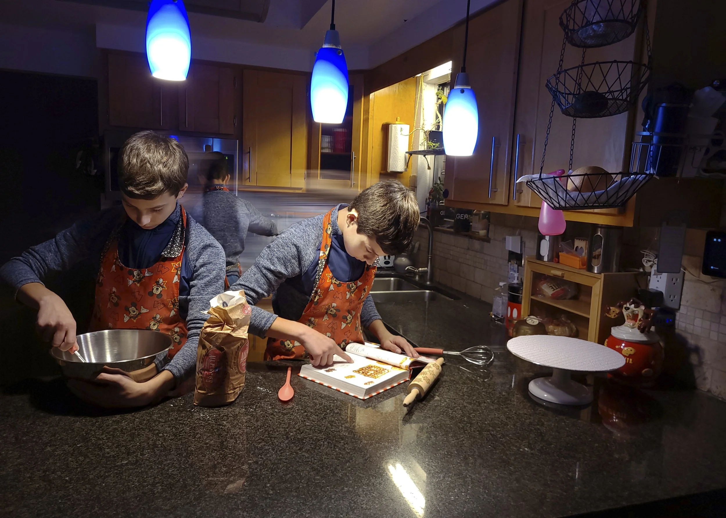 Austin Evans, "Chaos in the Kitchen," 2022.
Fort Collins teen Austin Evans is very busy in the kitchen late one evening as he rushes through many different steps to finish up his waffle batter. By preparing the mix the night before, it will be easy t