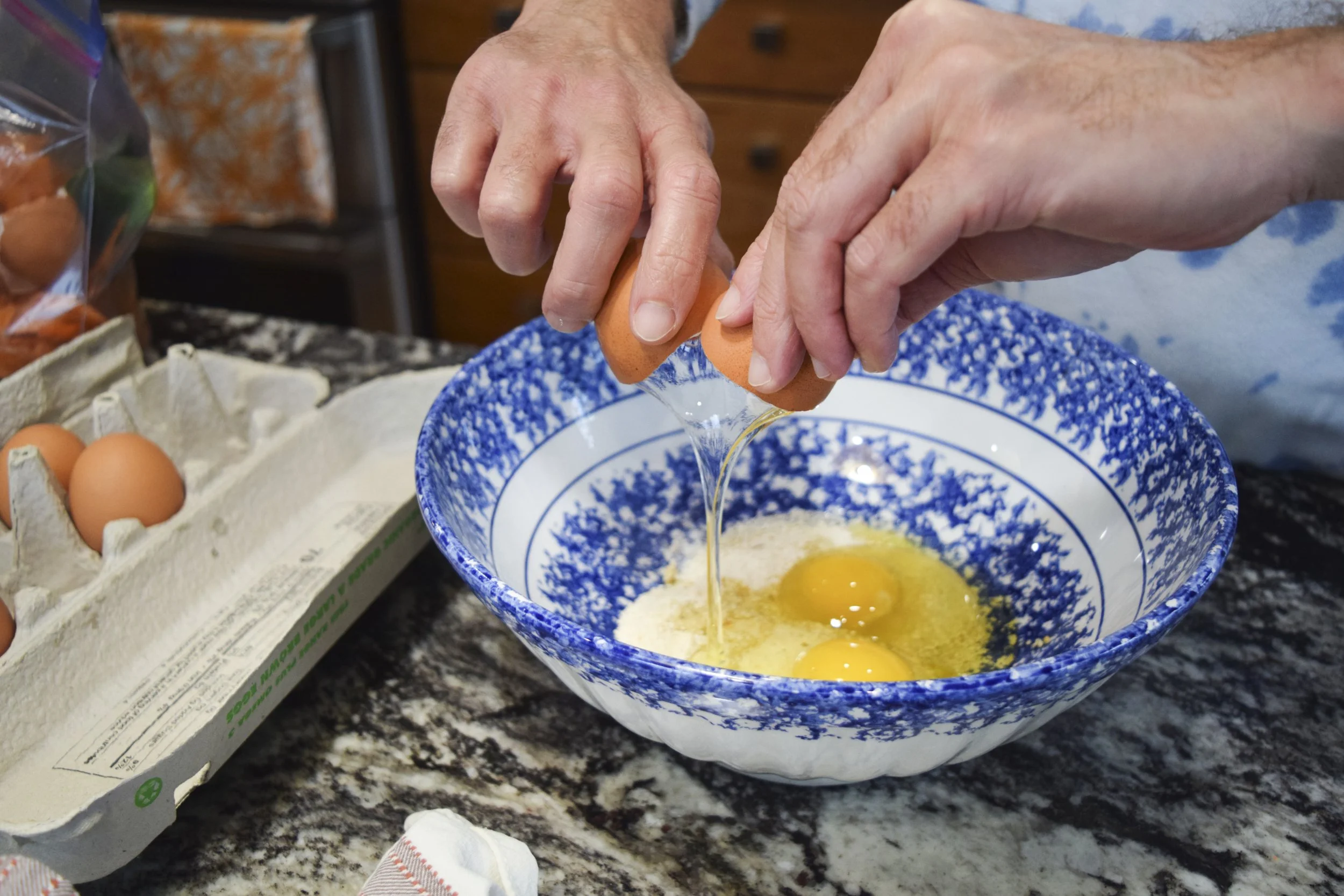 Remy Frank, "Making Matzah Balls," 2022.
On Passover, my family makes homemade matzah ball soup. My dad works in the kitchen, creating the matzah balls from scratch. He breaks the egg into the matzah meal and prepares to start this process.