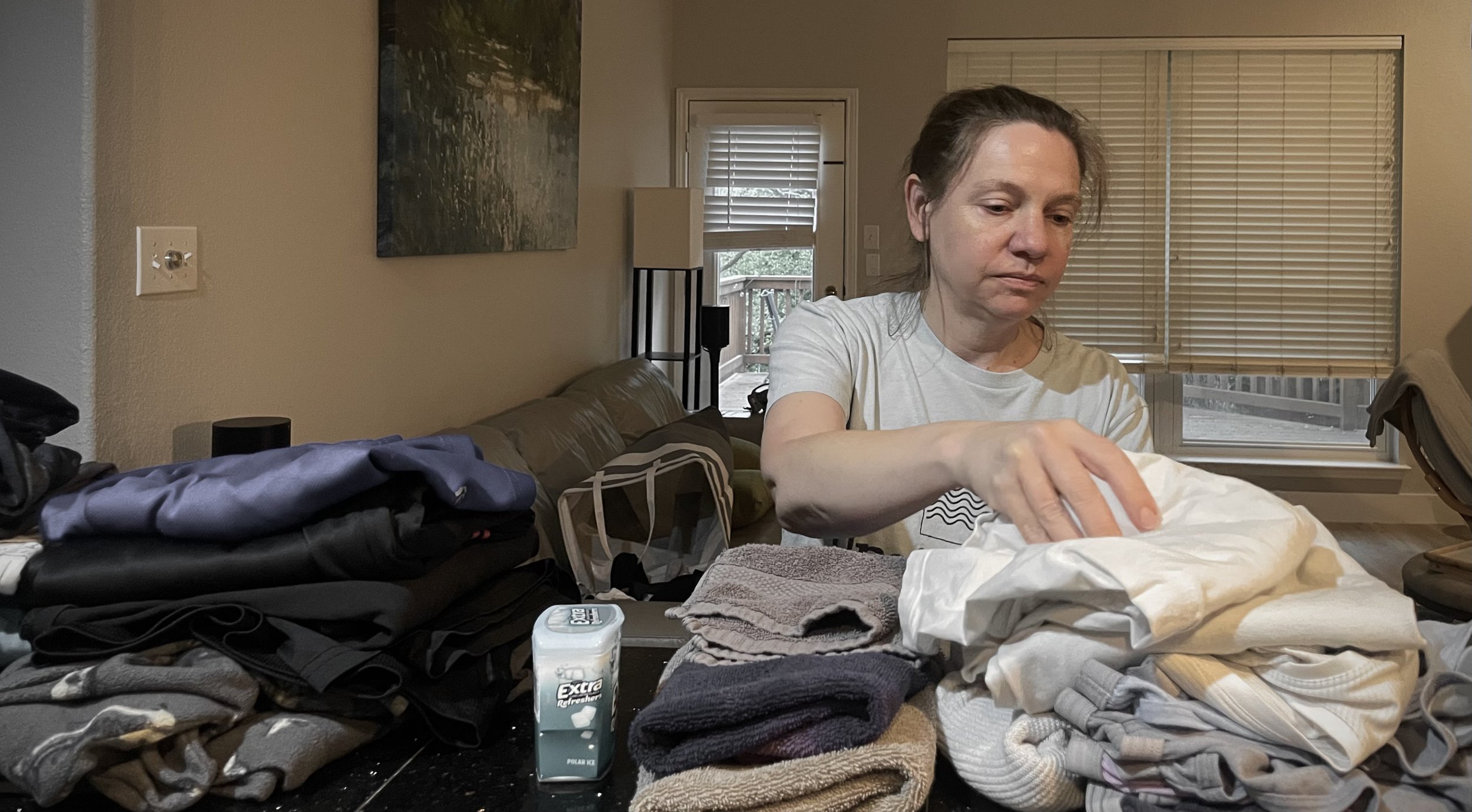 Eleanor Brownlee, "Clothes Piles," 2026. My mom, by far, does the most for our family. Despite what my dad may say, she does the majority of the household chores between the two of them, even though they both have full-time jobs. Here, she is doing l