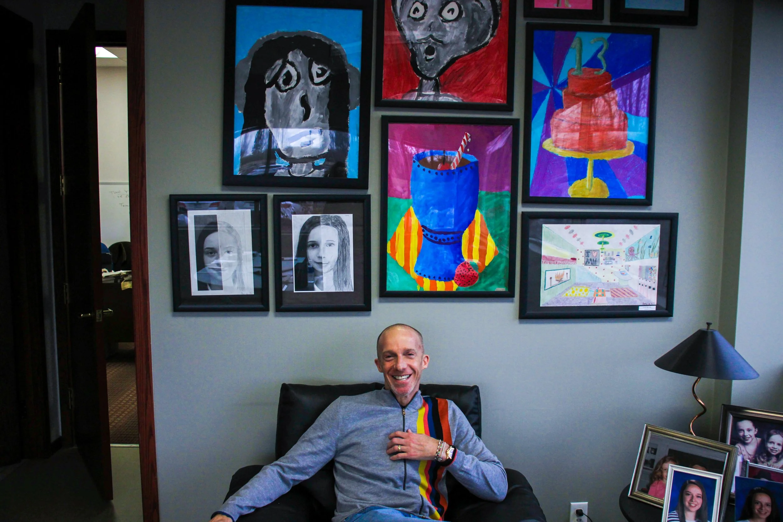 Annie Kristal, "Untitled," 2018. "My father sits in front of artwork made by my sister and me, in his office. He loves hanging our artwork and pictures of our family because he always says “family comes first.” This was the first picture I took at hi