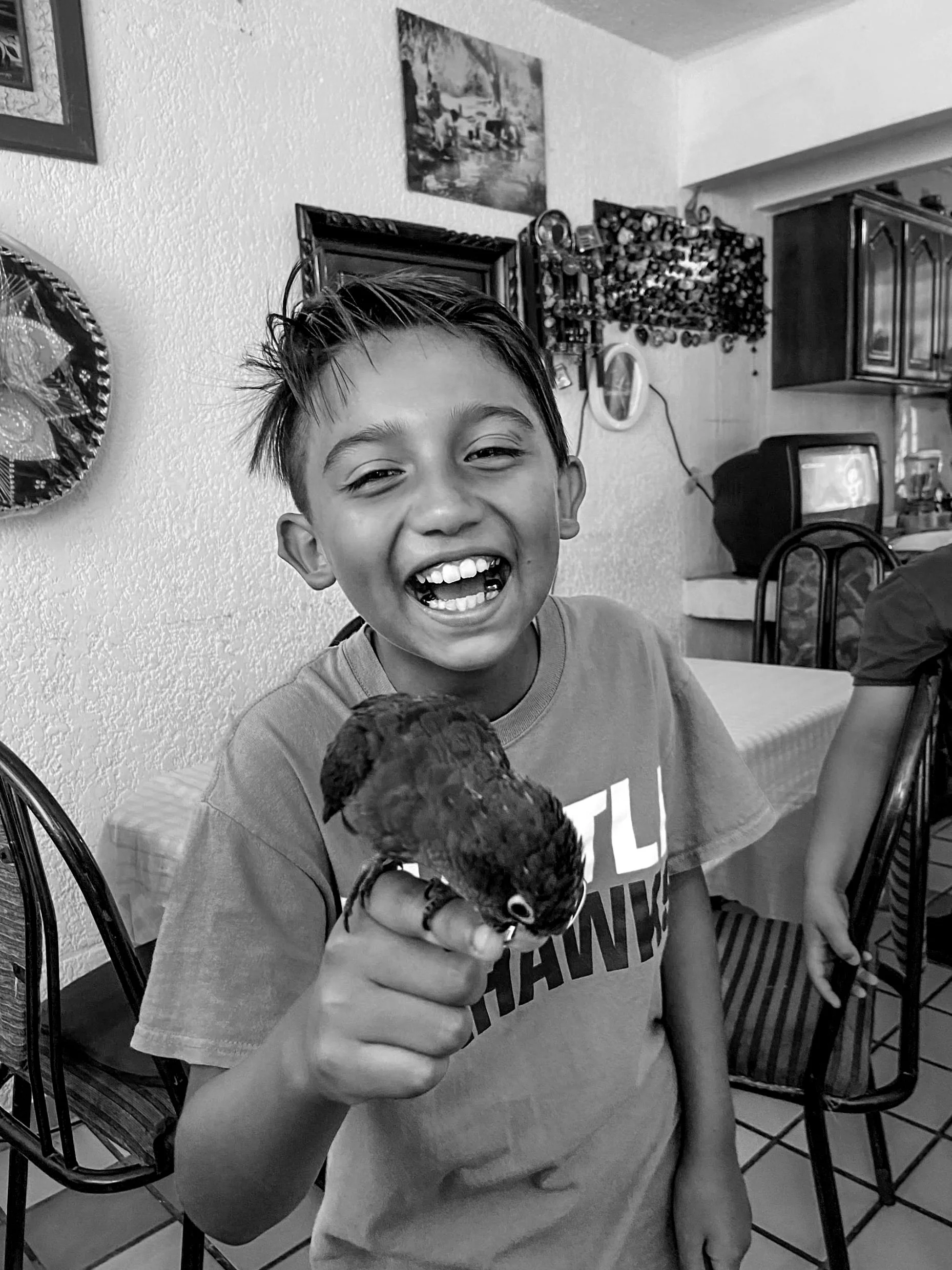 Andrew Bustos, "Danny with a Parrot on His Finger," 2021. Danny held my cousin's parrot for the first time and found it very amusing! Unfortunately, the parrot passed away due to illness the next day. Our pets become family. My cousin was responsible