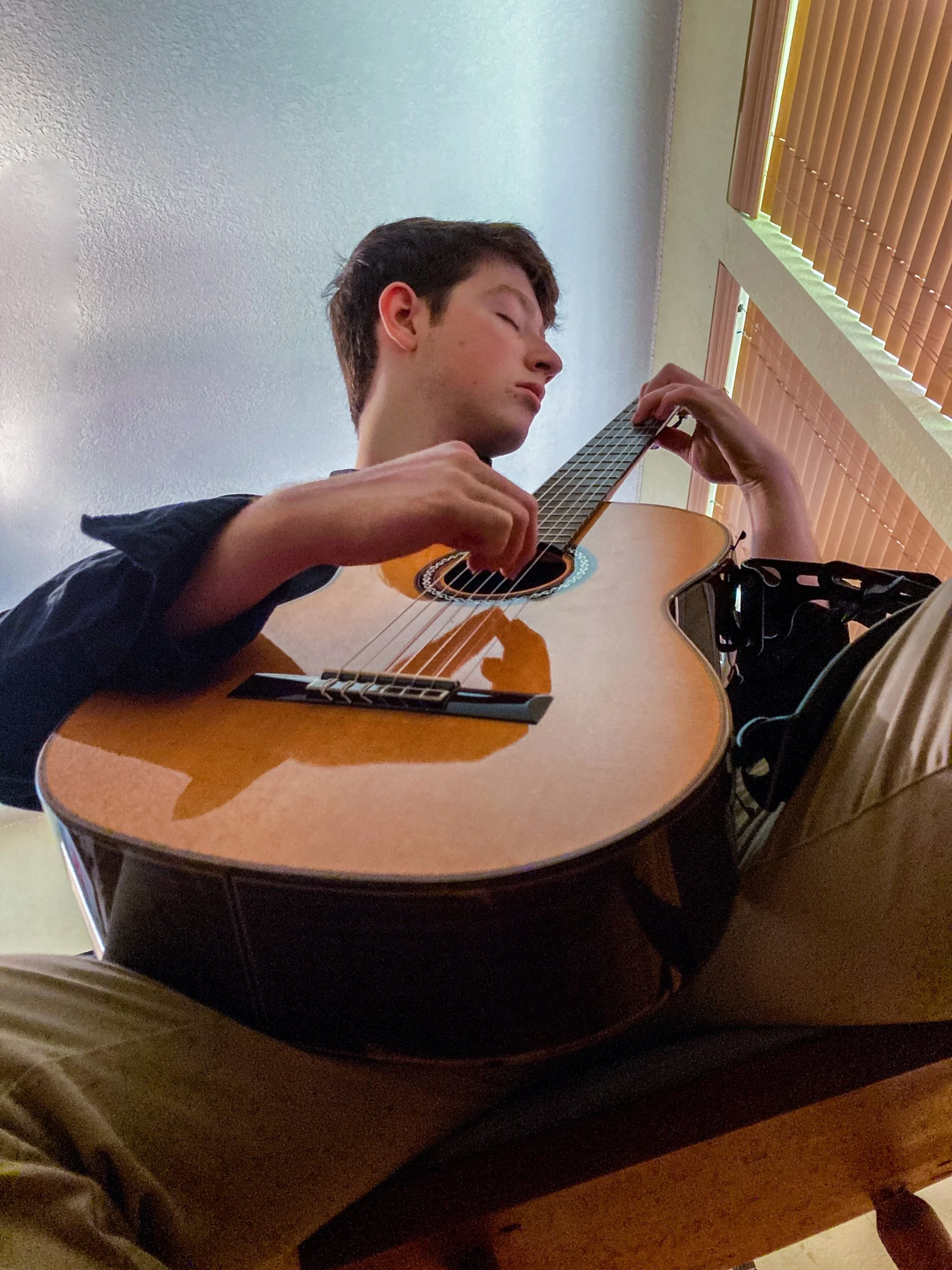 Meredith Grotevant, "Practice Makes Perfect," 2021. My brother sits intensely focused as he practices guitar in preparation for an upcoming performance. Music has always played an important role in my family, and a lot of our most cherished memories