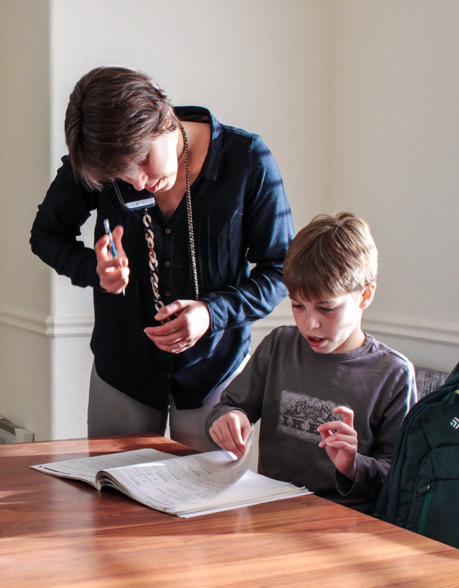 Amit Sela, "Multitasking," 2018. "The overlap of work and family in my household is complicated and fast-paced. There is always lots to be done in a small amount of time, which can make things stressful. In this photograph, my mom helps my brother wi