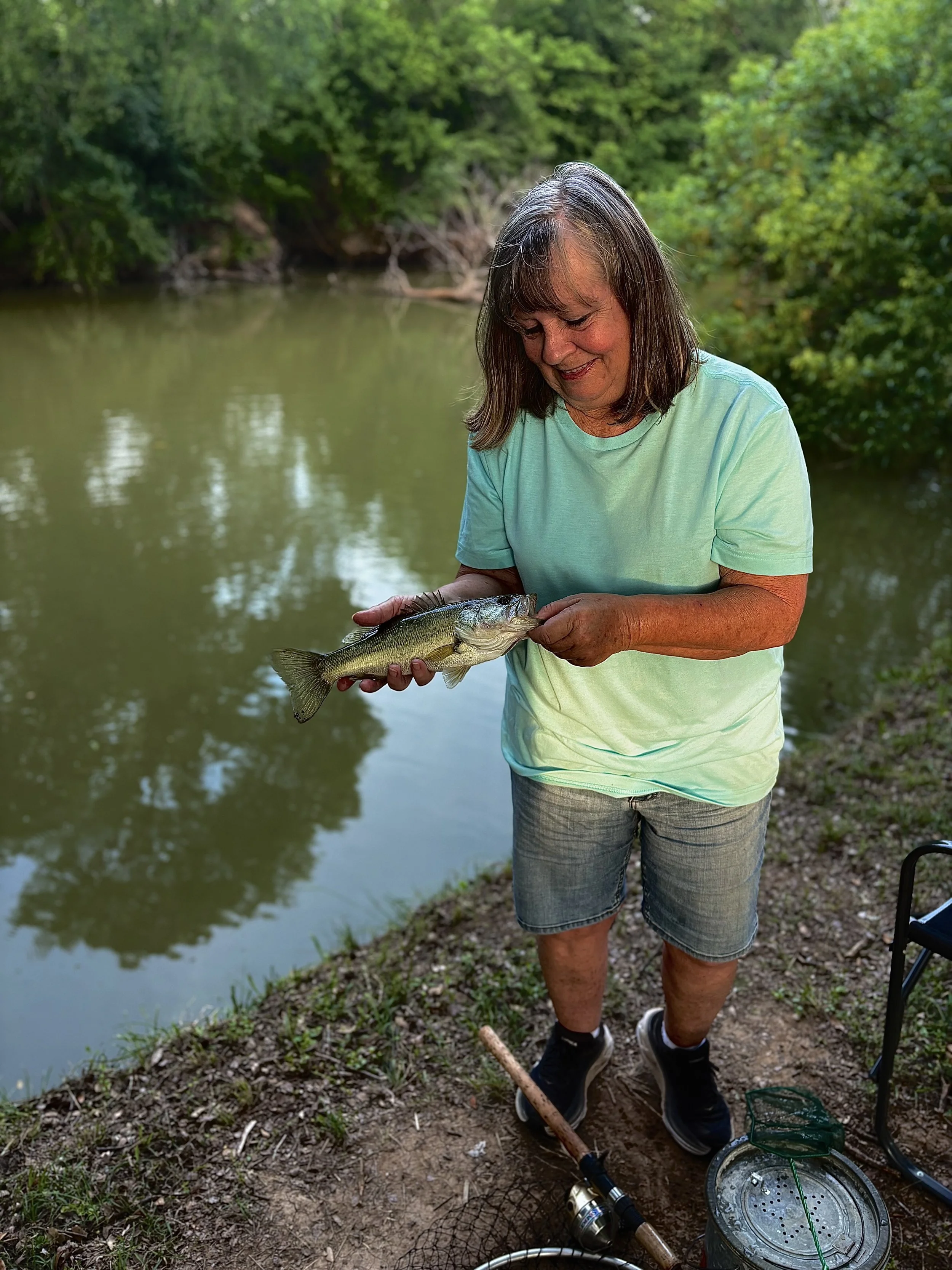 Schoen Thibert, "Fishing Buddy," 2026. This shows my aunt after catching one of the many fish of the day. She is excited to see us, especially when we come down from Austin to the country. We fish together for a long time because it’s the only thing 