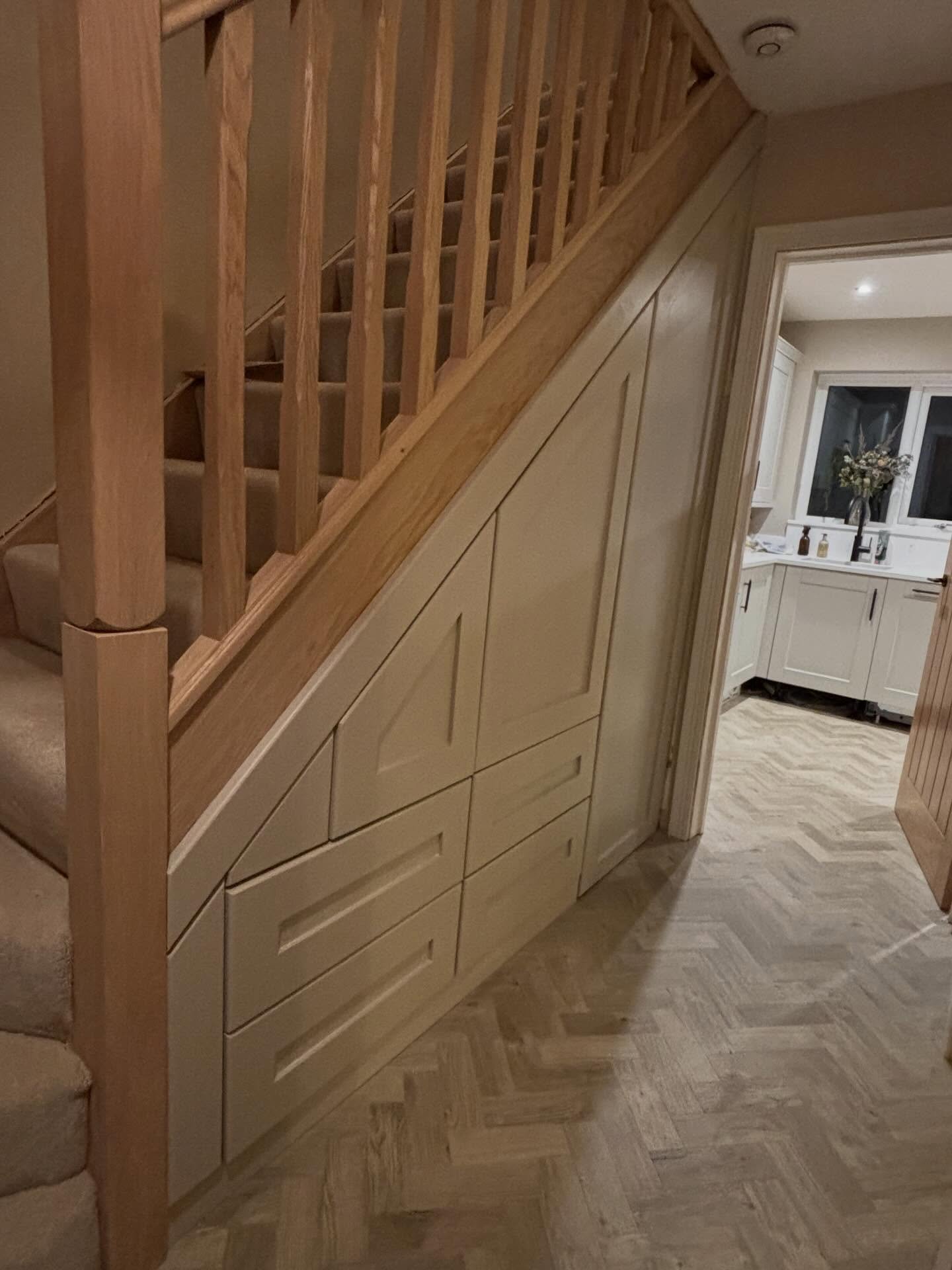 Where luxury meets intelligent design.

This bespoke understair installation transforms overlooked space into refined, functional storage &mdash; seamlessly integrated with solid oak stair detailing and precision joinery. Every panel is handcrafted, 