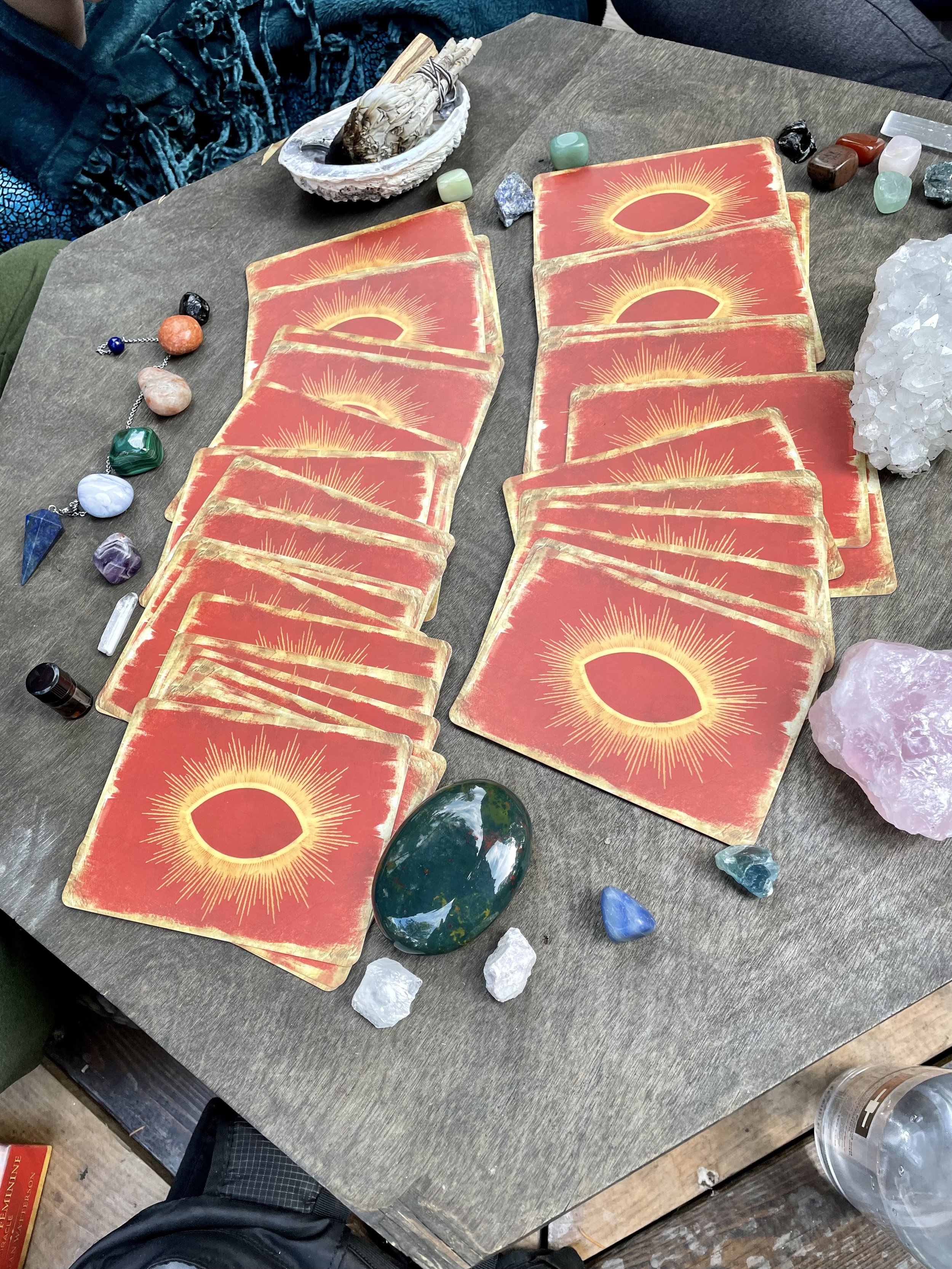 Table with tarot cards, crystals, and sage for spiritual reading