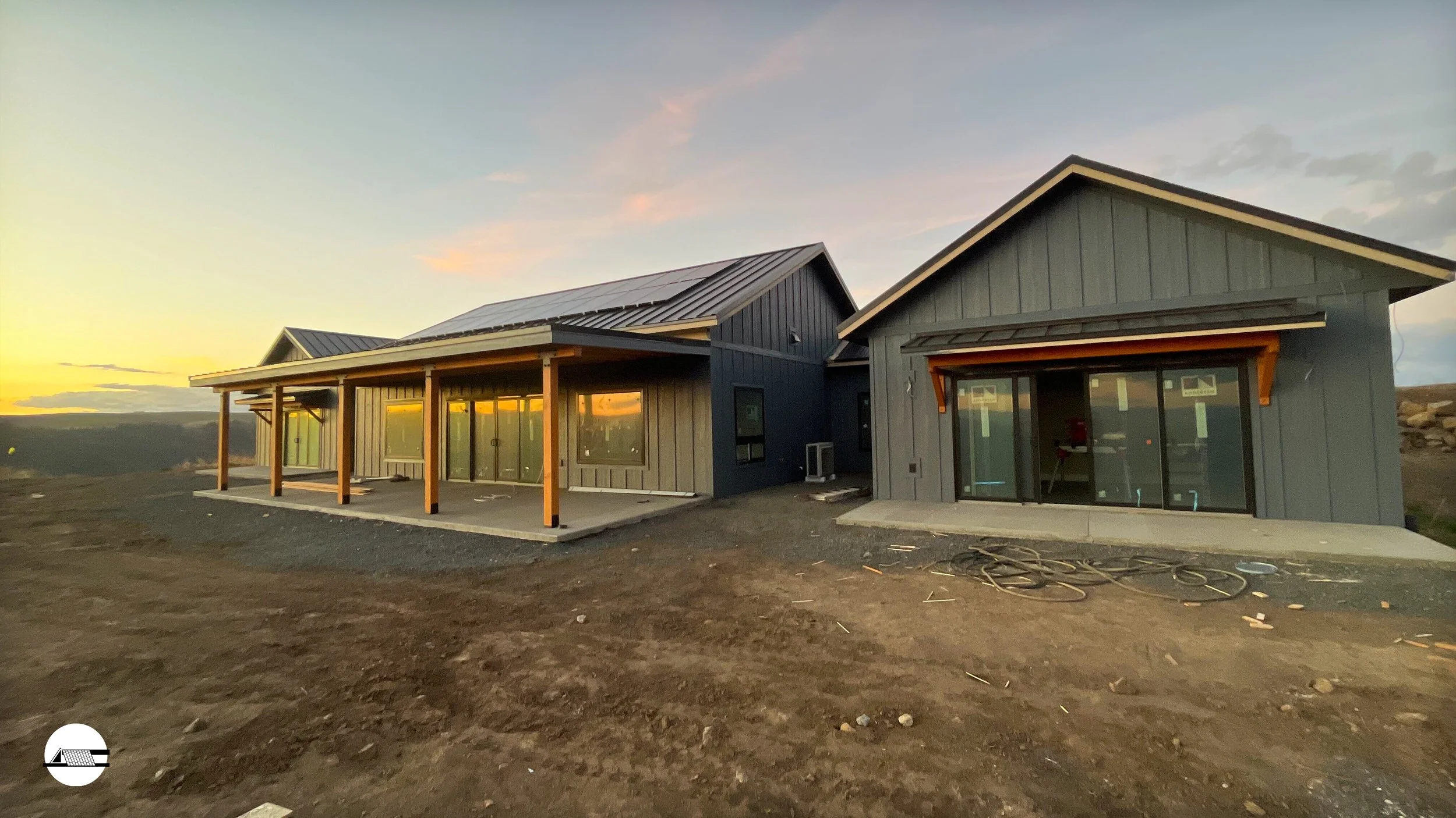 Construction site with a finished shop and house under construction with views over hills