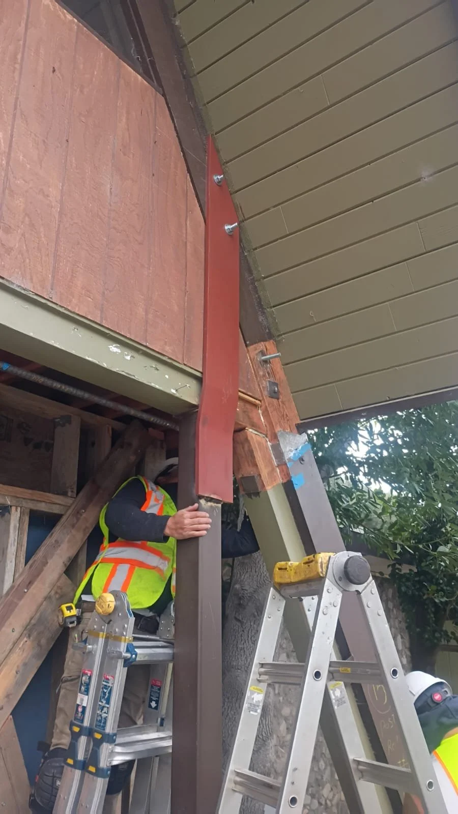 Worker positioning steel reinforcement beneath the lodge roof.