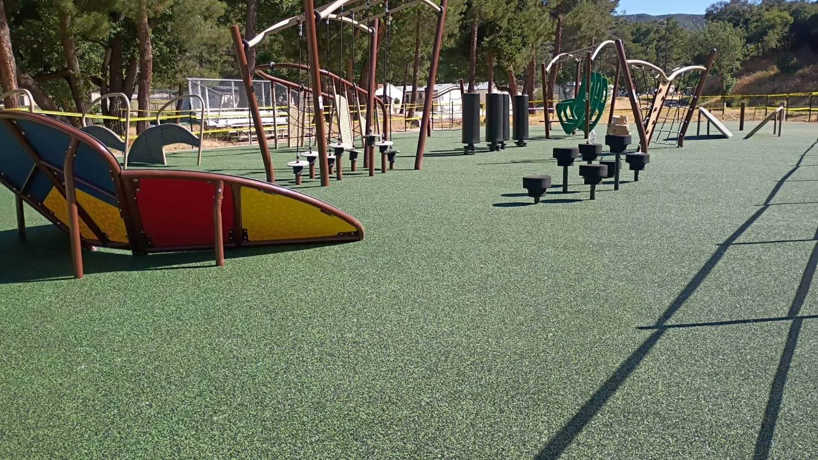 Wide view of installed obstacle course equipment and green surfacing.