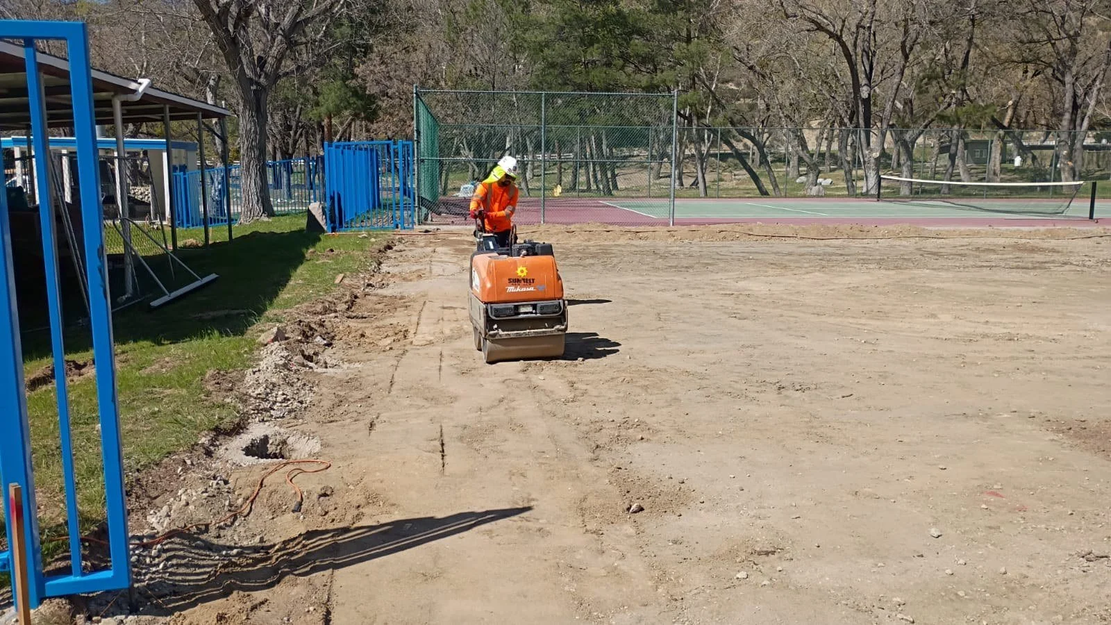 Ground compaction in progress beside the existing court.