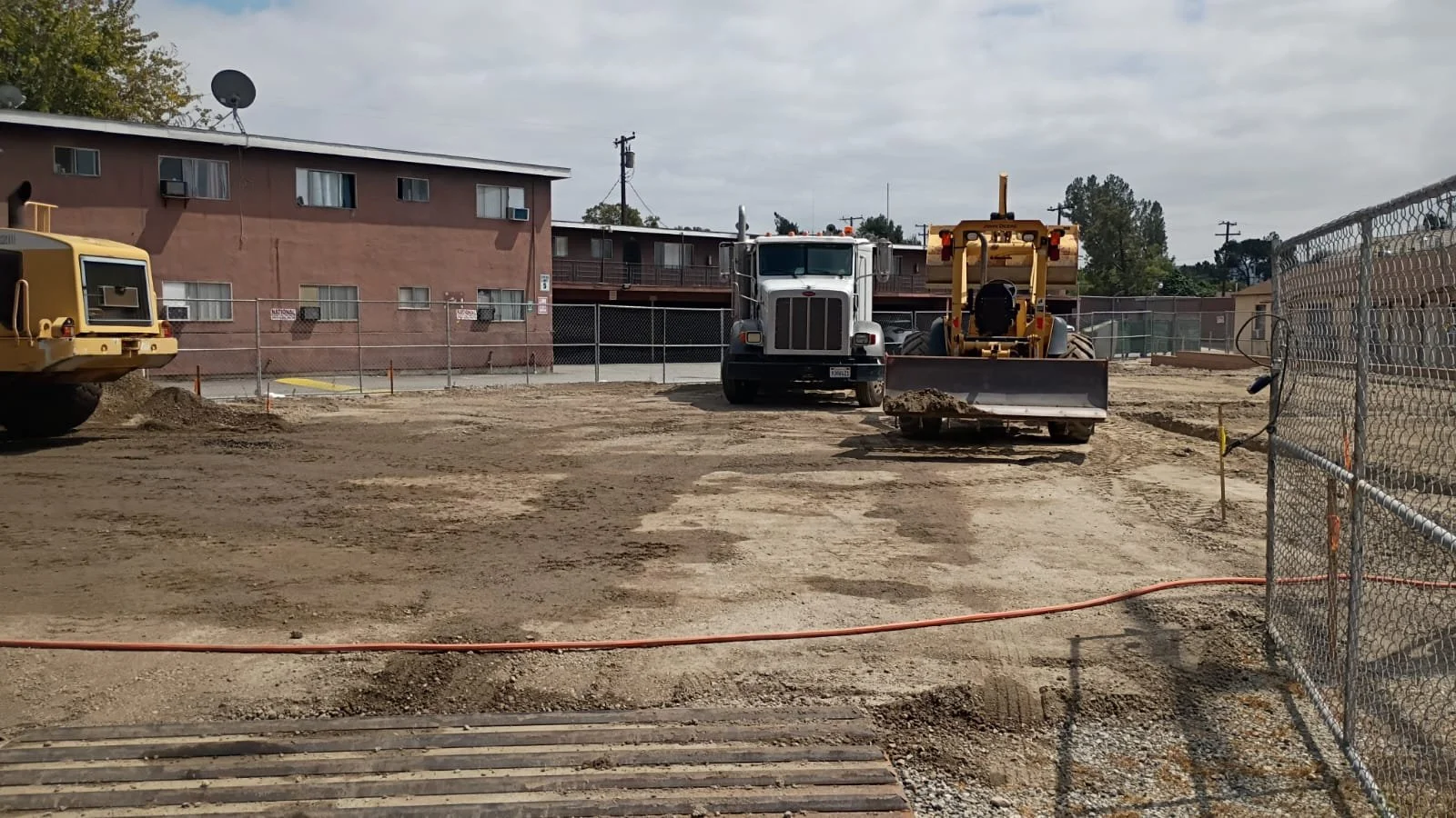 Grading equipment and a dump truck preparing the construction site