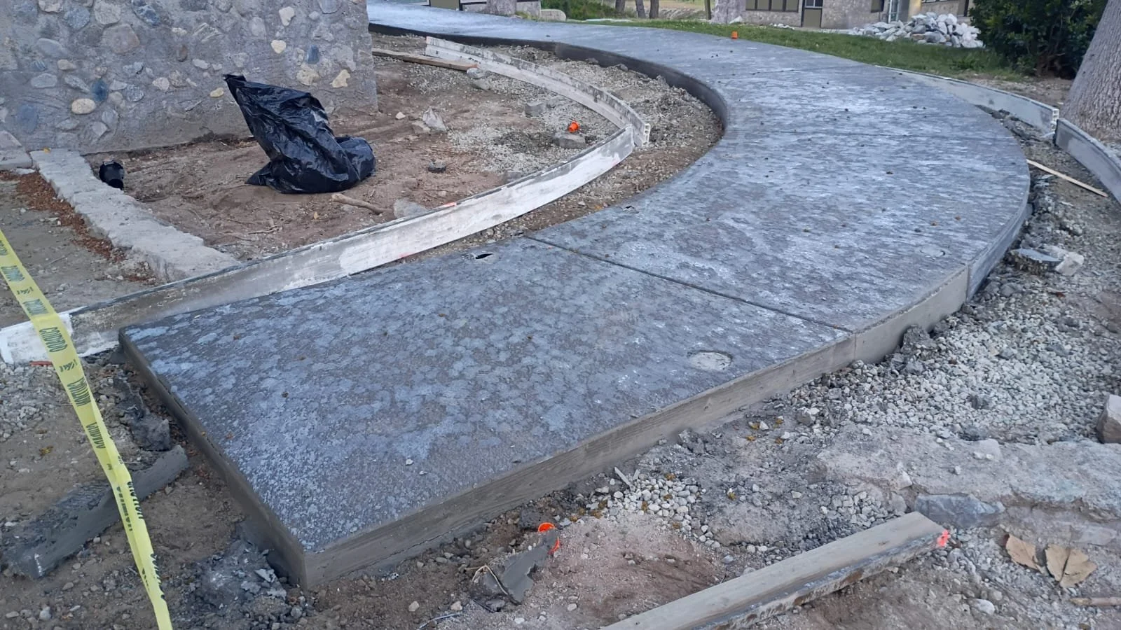 Curved concrete walkway beside the lodge’s stone walls.