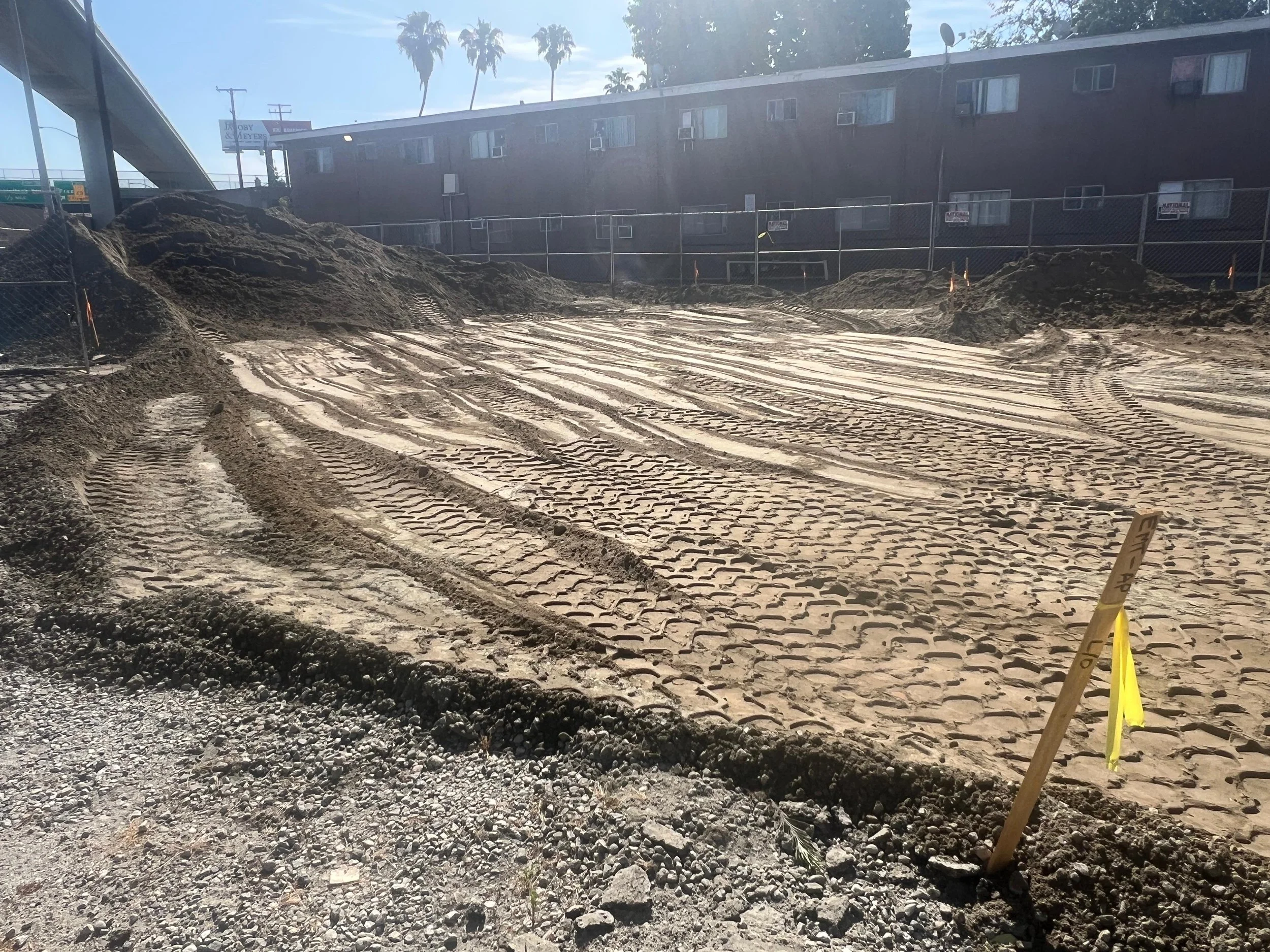 Excavated construction site with graded soil and equipment tracks