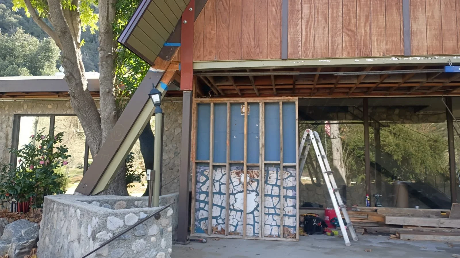 Exposed wall framing and steel reinforcement at the lodge entrance.