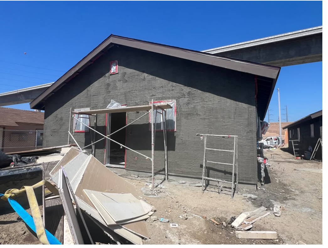Stucco exterior work around a building entrance and windows