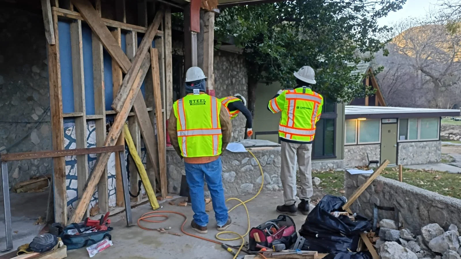Construction crew working beside exposed framing at the lodge entrance.