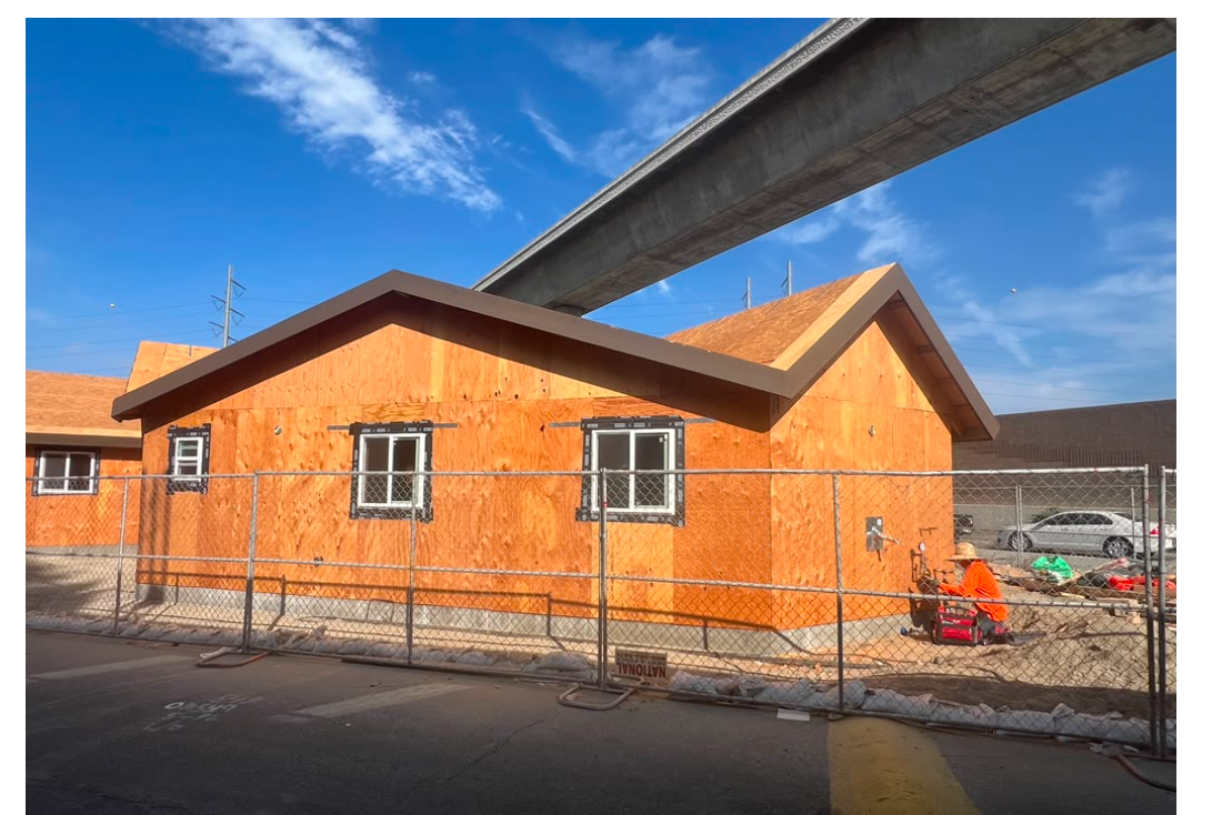 Building exterior with plywood sheathing, installed windows and gabled roofs
