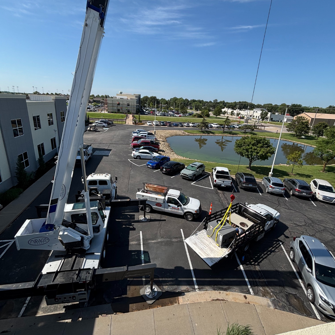 Crane and crew staging HVAC unit before rooftop lift in Wichita Kansas