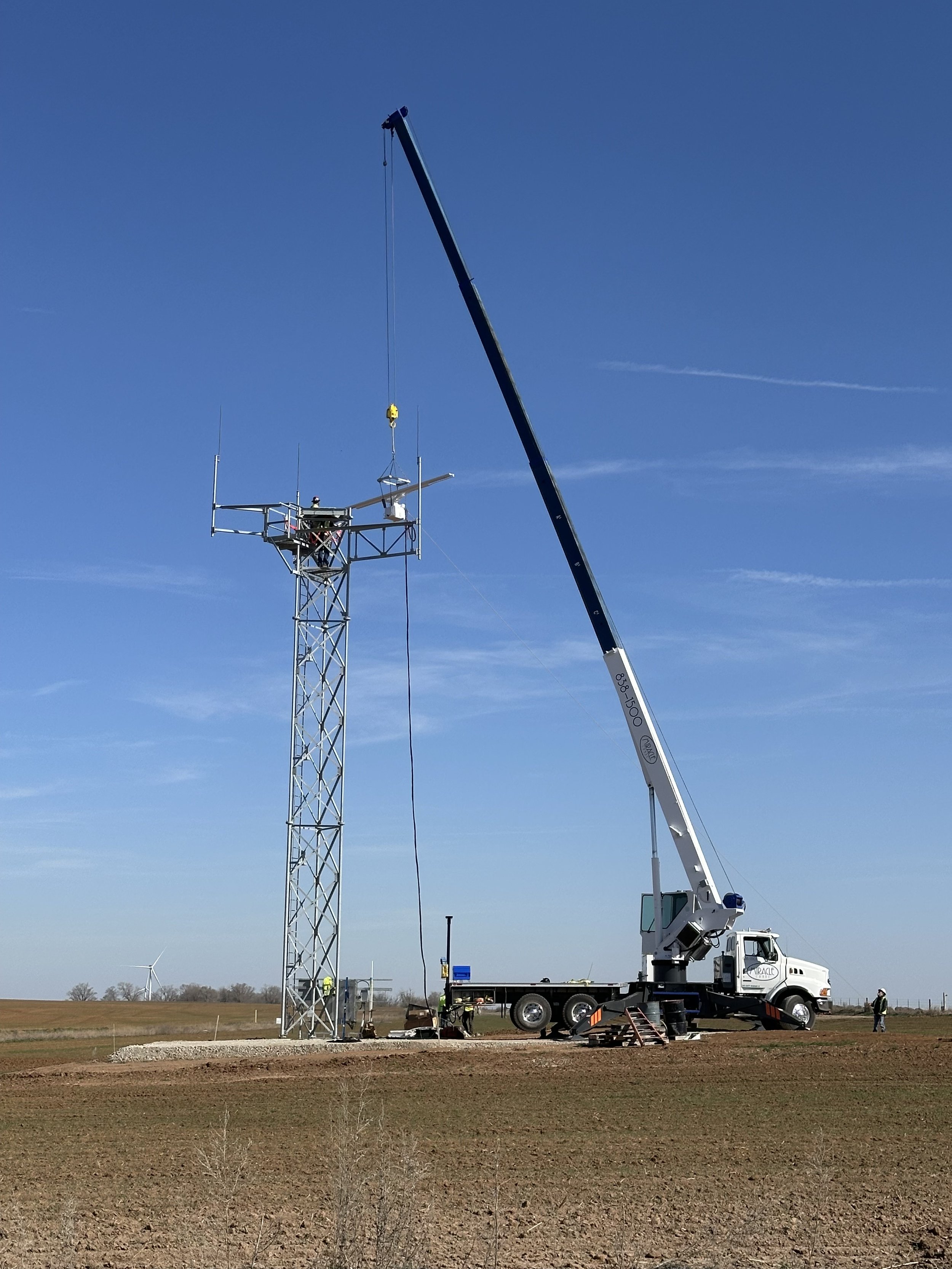 Miracle Crane lifting a metal tower into place at an airport job site in Kansas