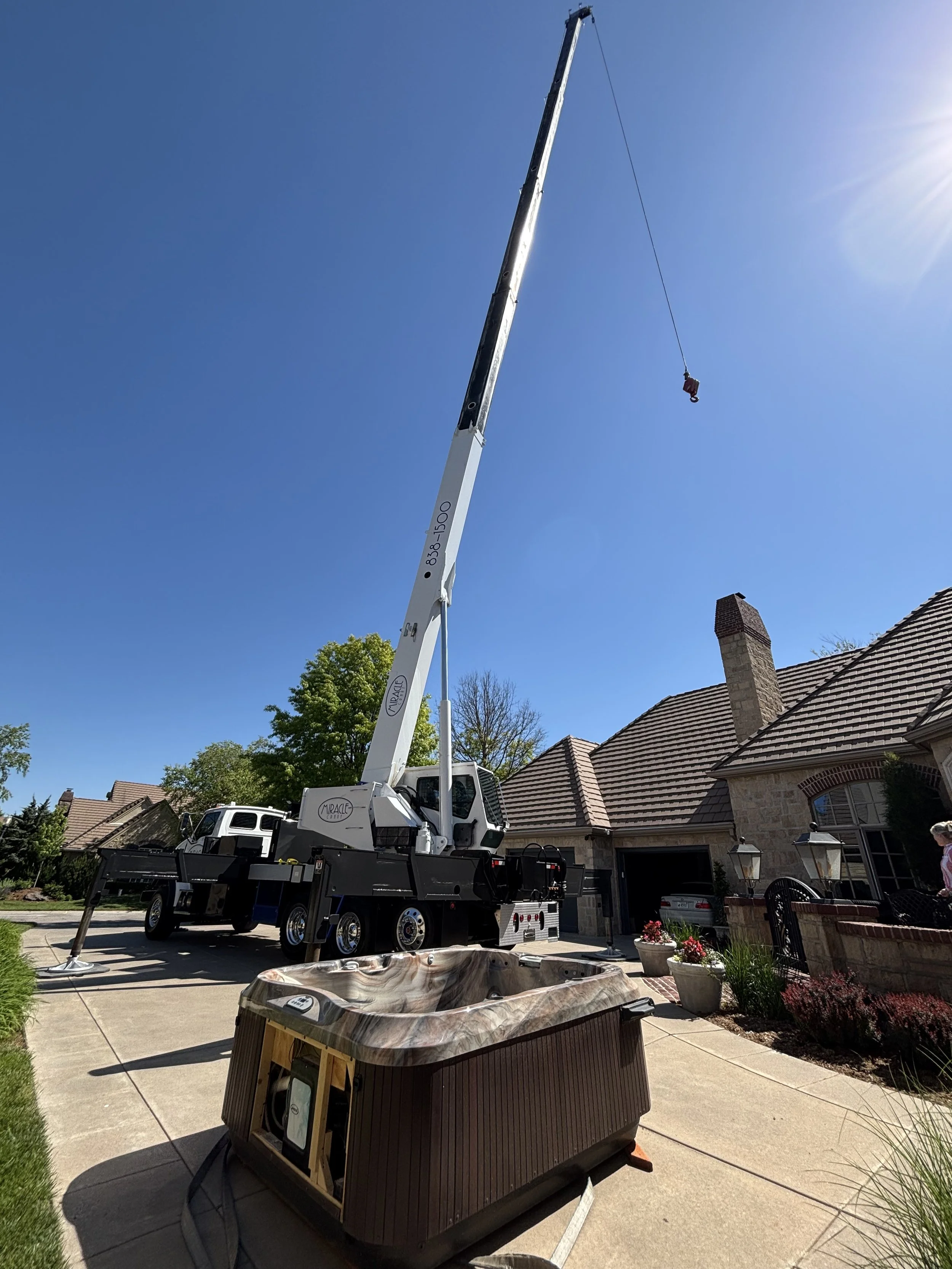 Hot tub on drive way after Miracle Crane has lifted the hot tub over the house in South-central Kansas