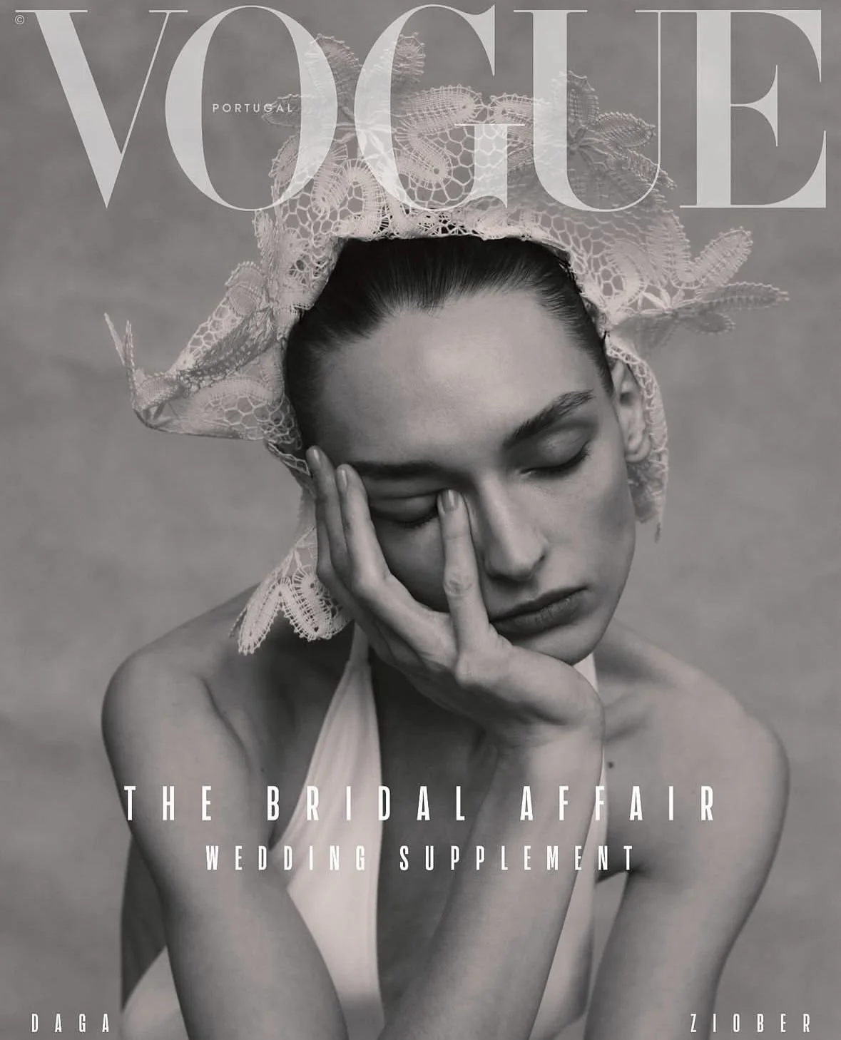 Black and white Vogue magazine cover featuring a woman with her eyes closed, wearing a lace headscarf and a halter top, with her hand resting on her face.