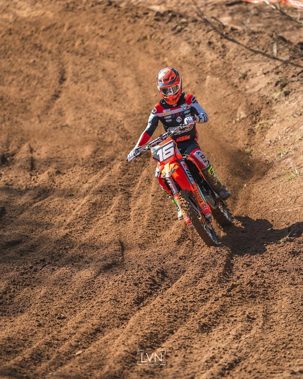 motocross rider cornering on dirt track during race
