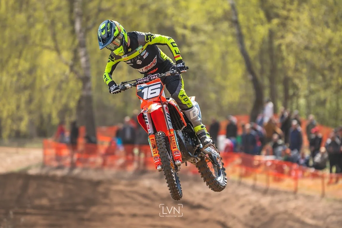 motocross rider jumping during race on dirt track