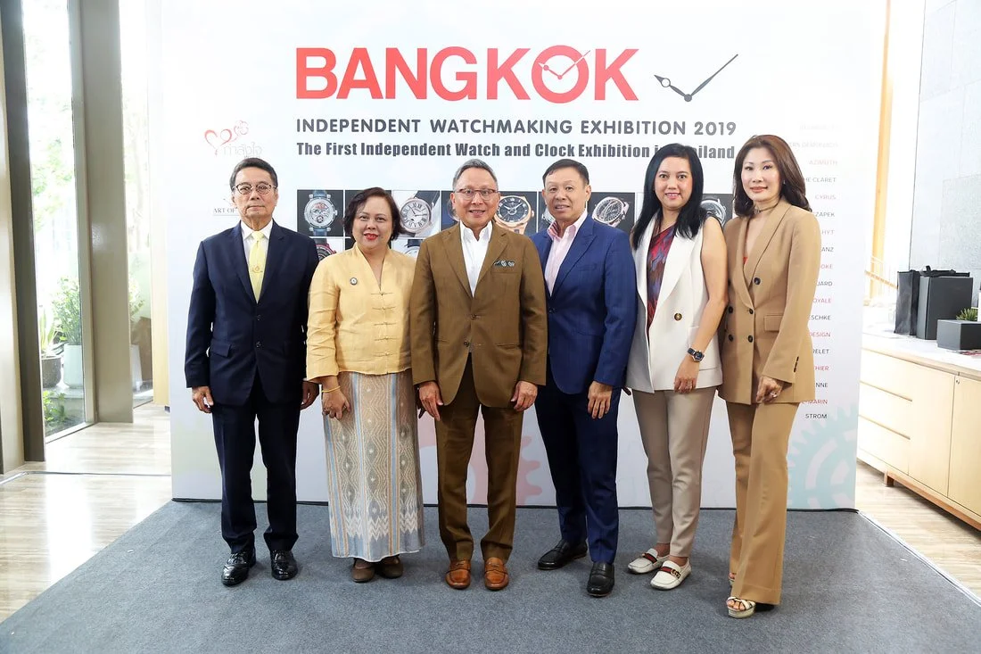 Group of six people standing in front of a display with watches at the Bangkok Independent Watchmaking Exhibition 2019.
