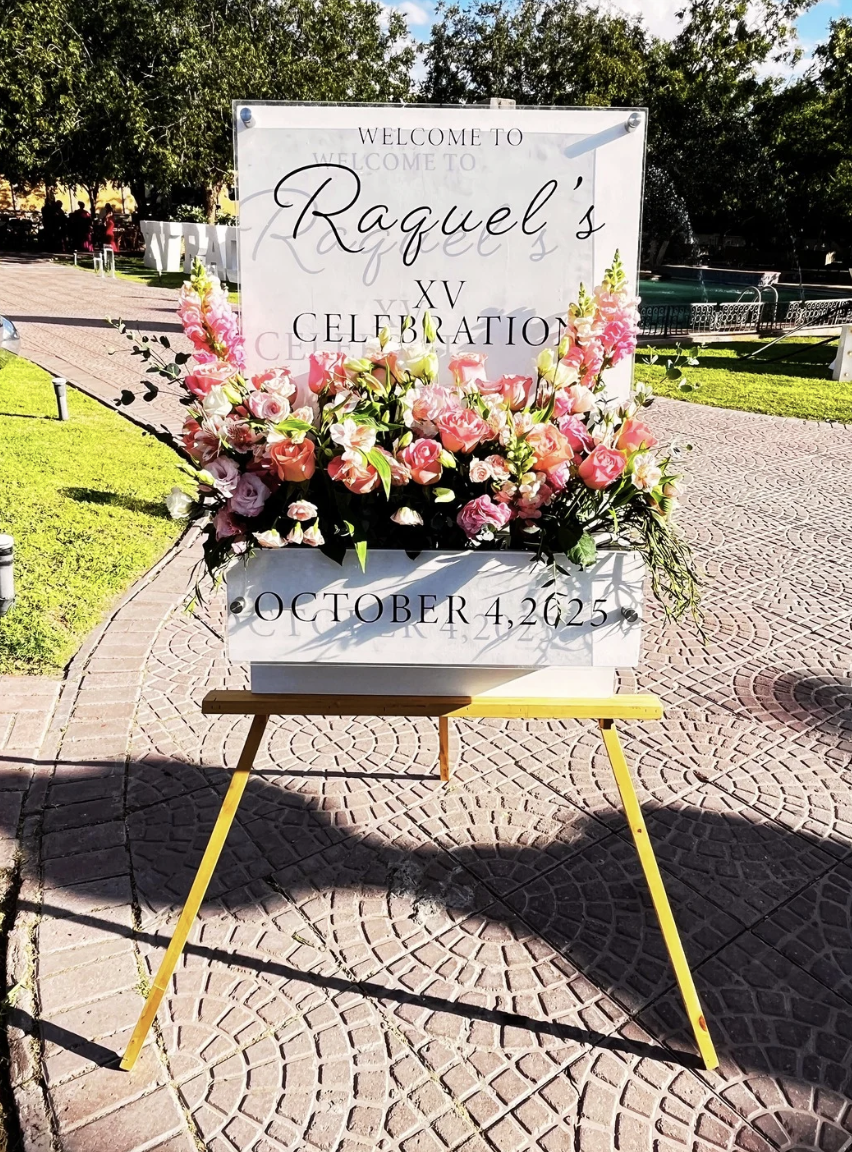 Letrero de bienvenida para XV años con arreglo floral en tonos rosas, montaje decorativo para evento social realizado por Petalia en Ciudad Juárez