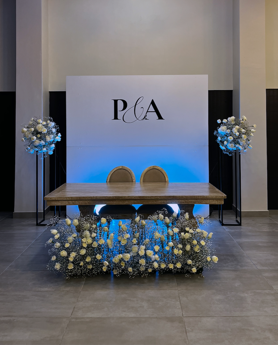 Backdrop floral para boda con mesa de novios, arreglos florales blancos y ambientación elegante diseñada por Petalia en Ciudad Juárez