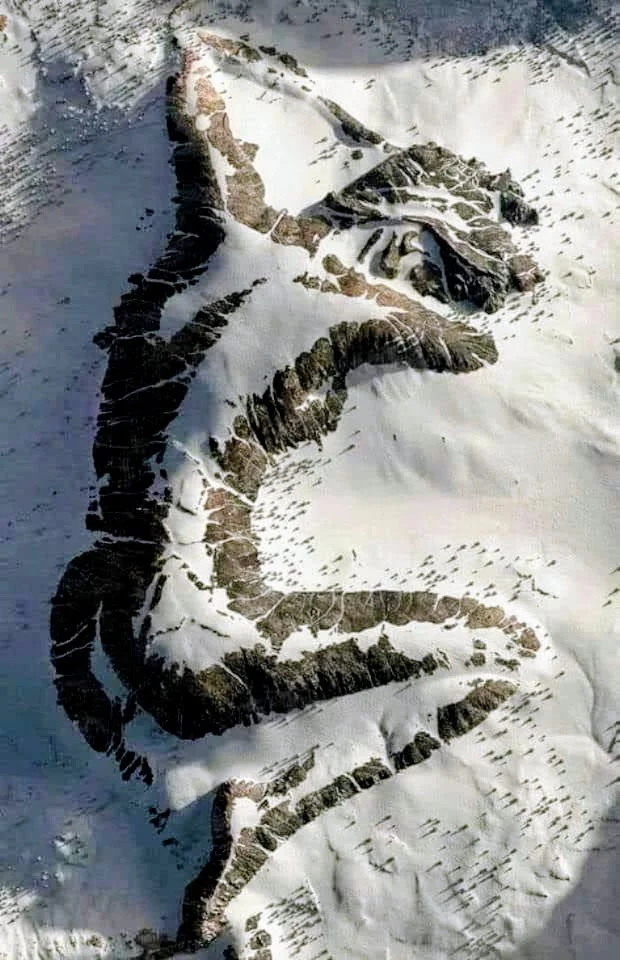 Aerial view of a snowy mountain landscape shaped like a horsetail or possibly a dragon.