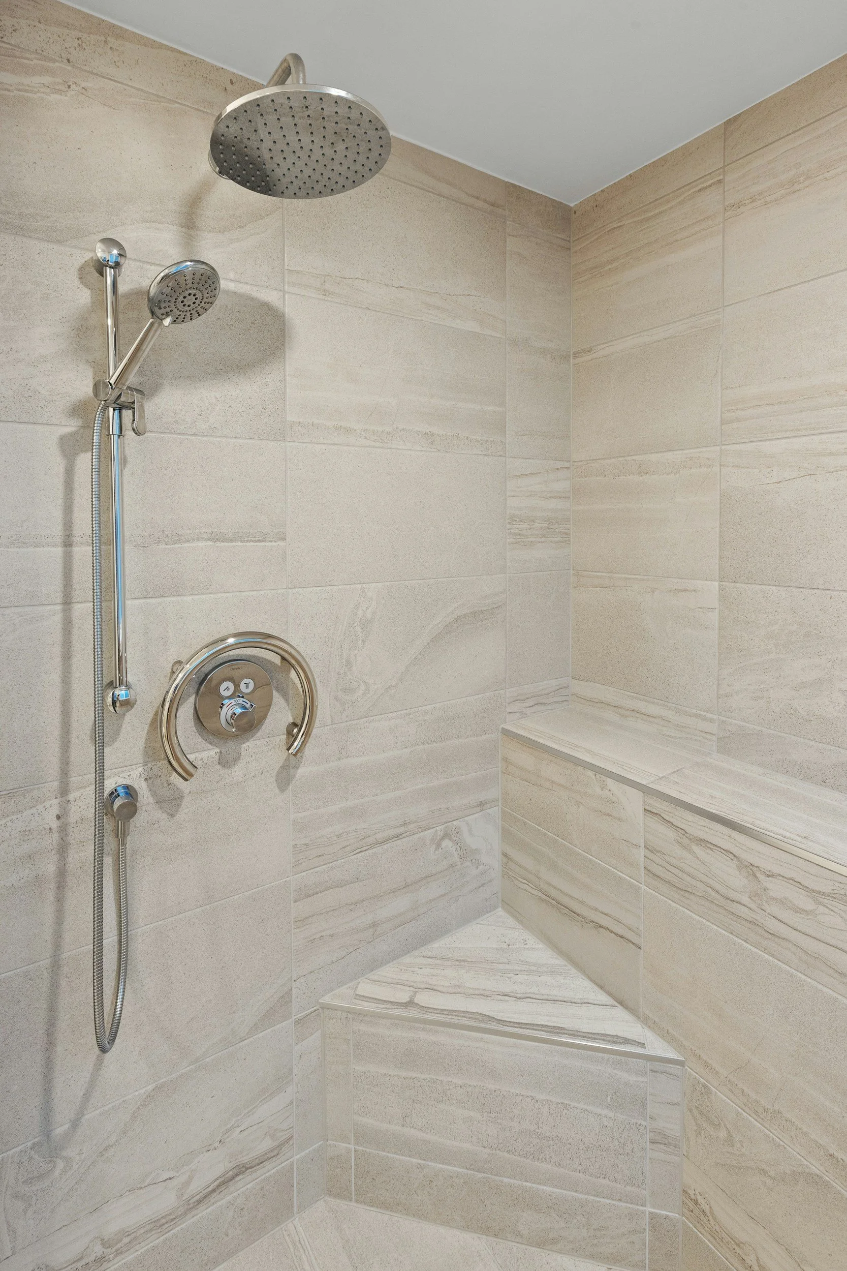 Walk-in shower with rainfall showerhead and large-format stone tile