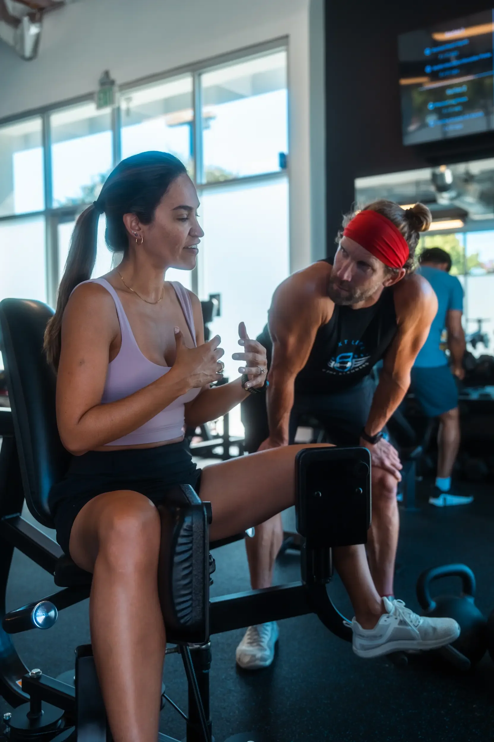 Coach reviewing a member’s benchmark lift during a strength training class in San Jose