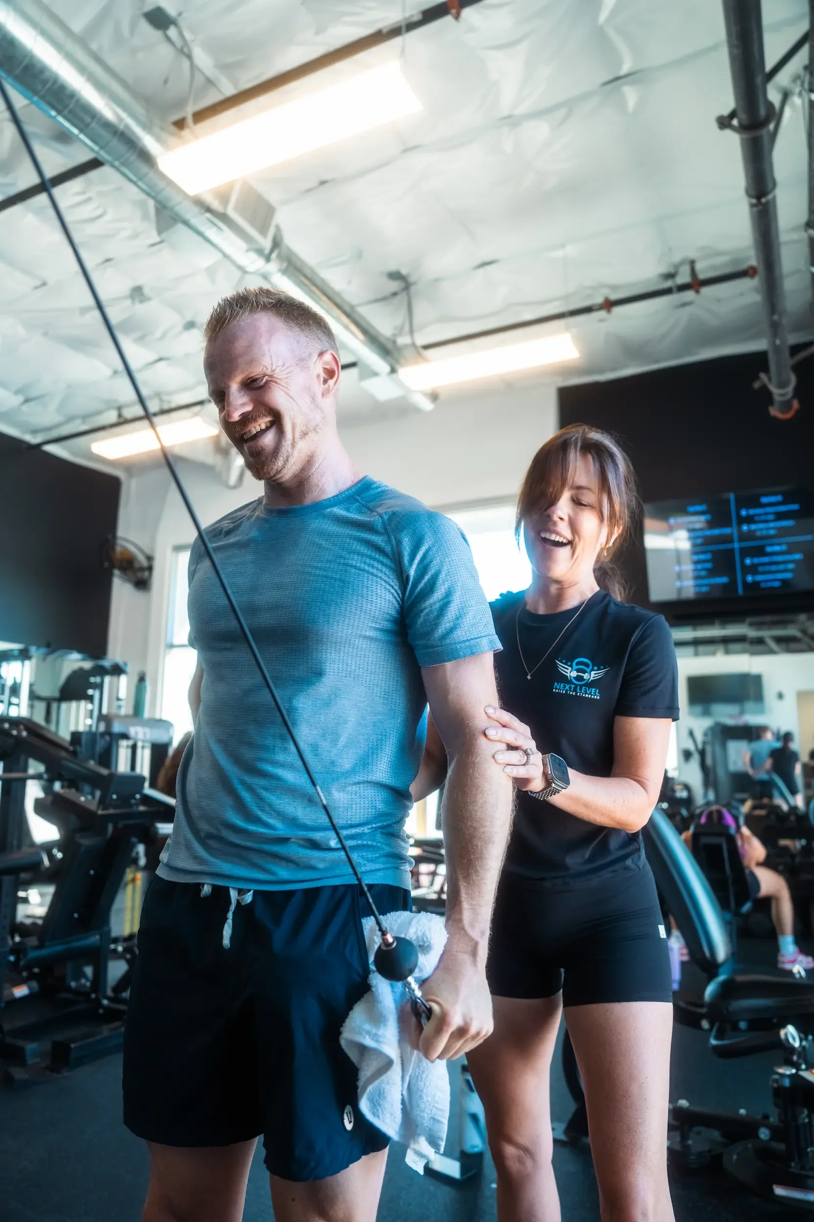 Certified coach correcting a member’s form in a small-group strength class