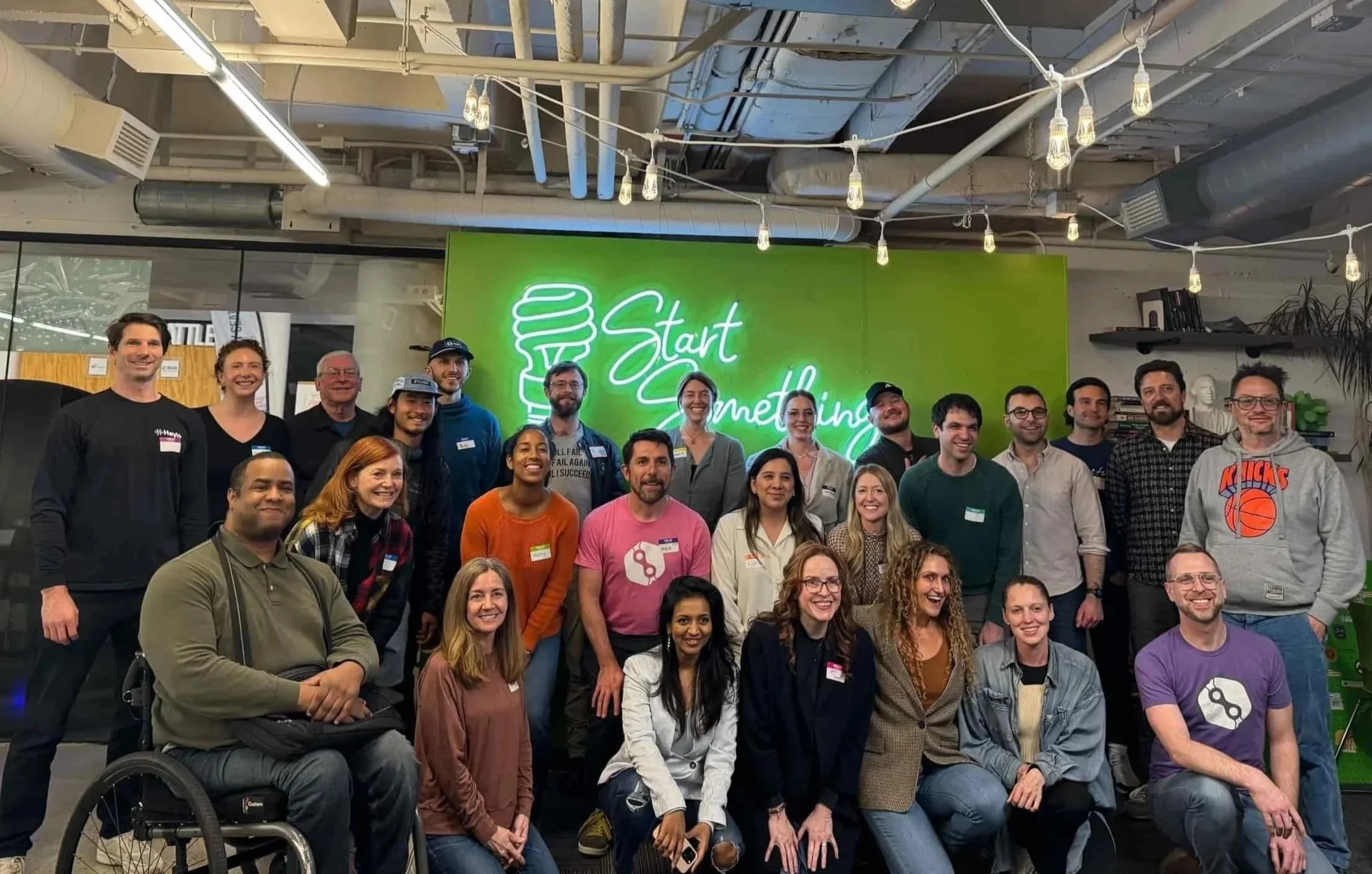 diverse group of people standing in a room with a green background