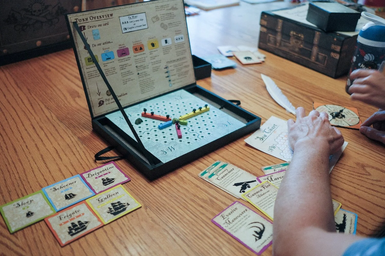 A player engaged in a board game, spinning a spinner, with colorful game pieces scattered around.