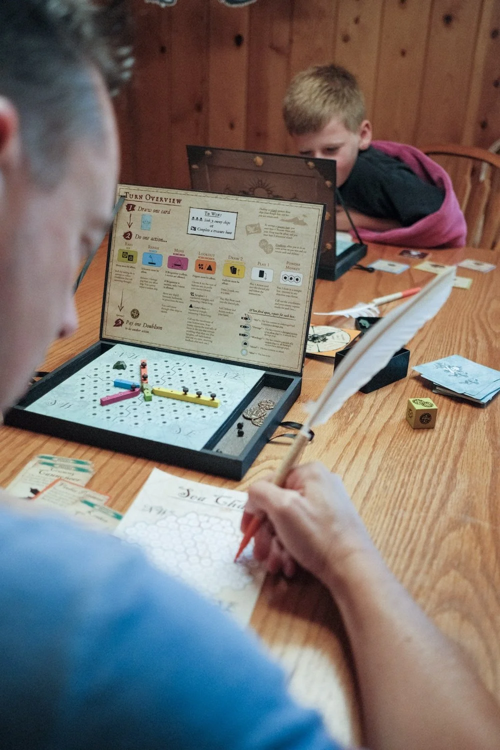 A boy and a man enjoy a fun board game together, sharing laughter and quality time in a cozy setting.