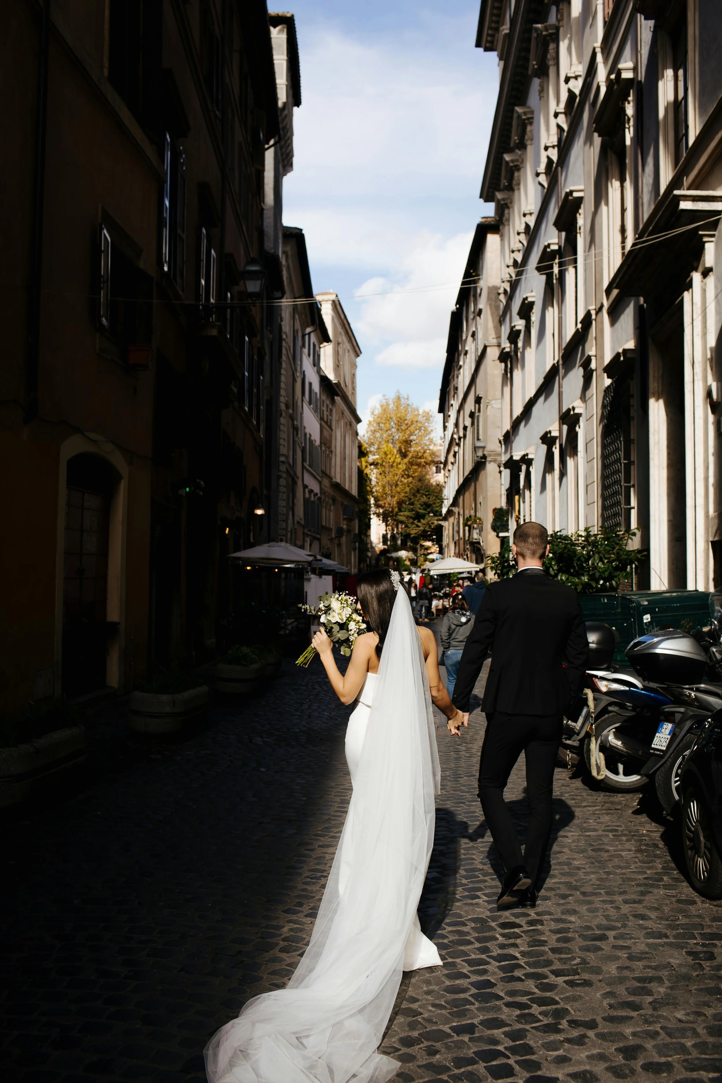 Laurie’s customers, Mariana and Carmen holding hands on a green lawn on their wedding day.