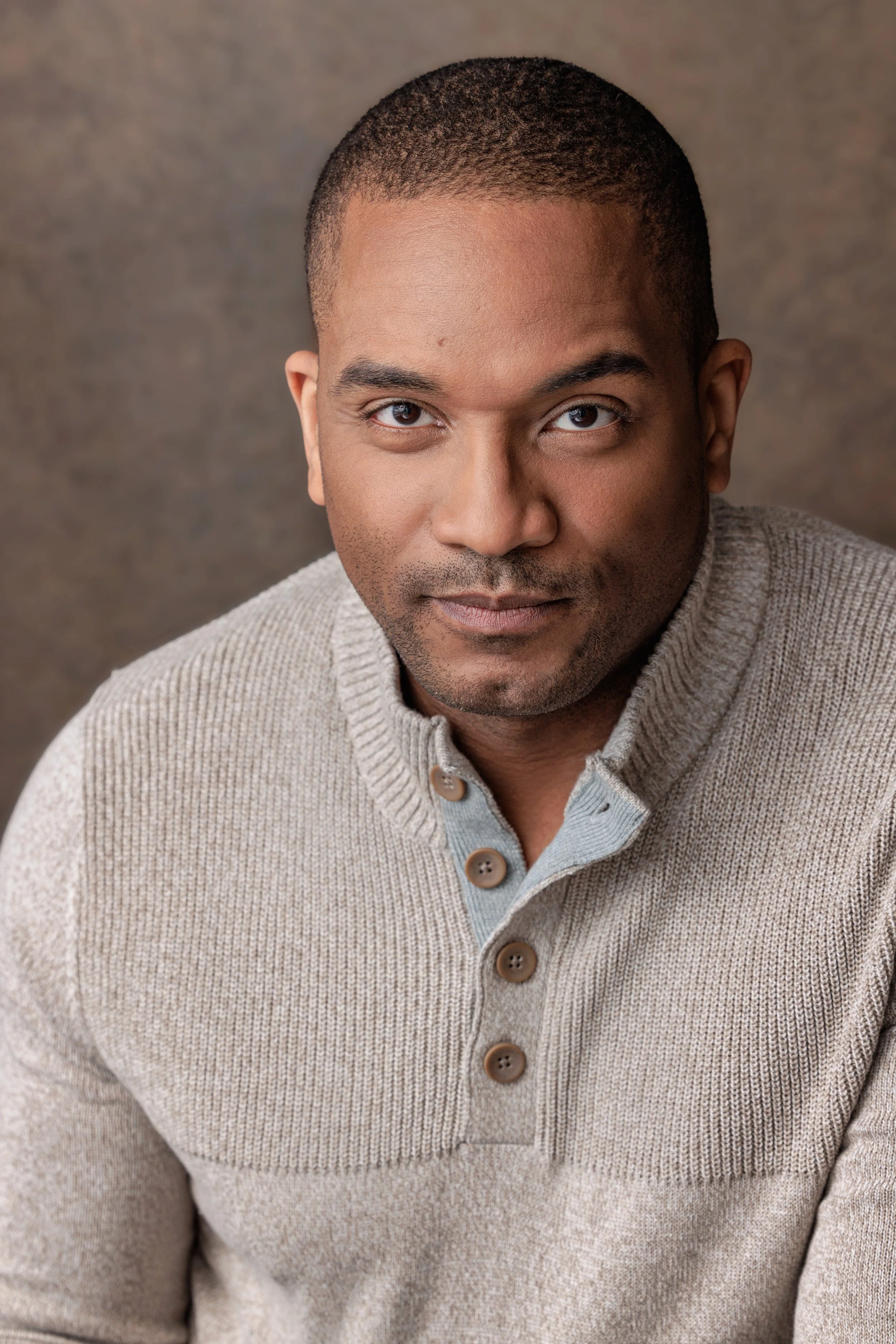 Film and TV actor Craig Galloway in a commanding and intelligent pose against a brown canvas backdrop.