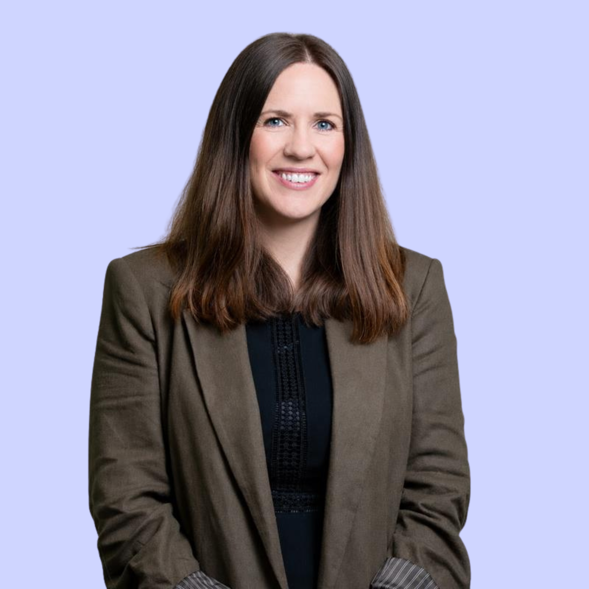 Louise with glasses and long brown hair against a peach background, wearing a green sweater.