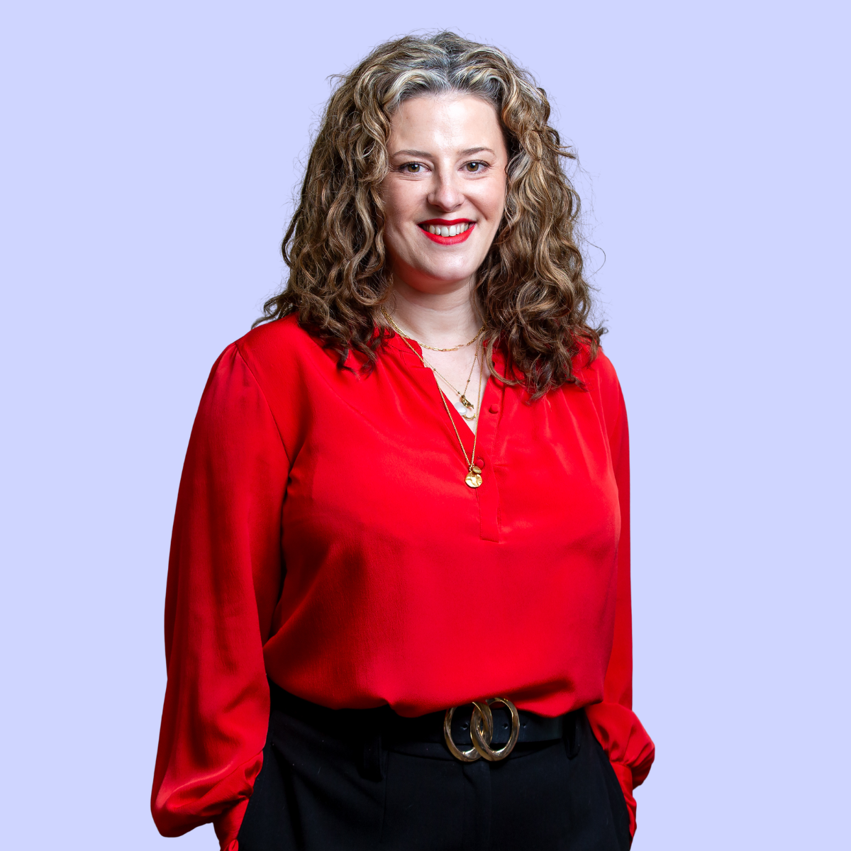 Claire with long hair wearing a light blue blazer and black top against a solid blue background.