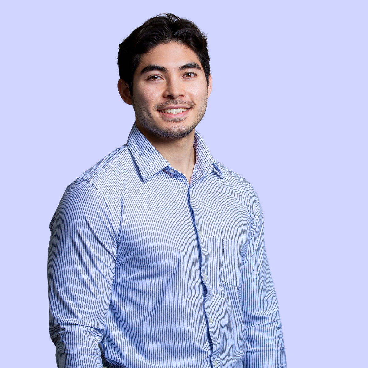 Brendan in green polo shirt smiling against a light blue background