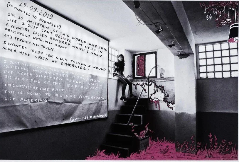 Person sitting on a ledge in a minimalist, industrial-style room with large windows and overhead lights.