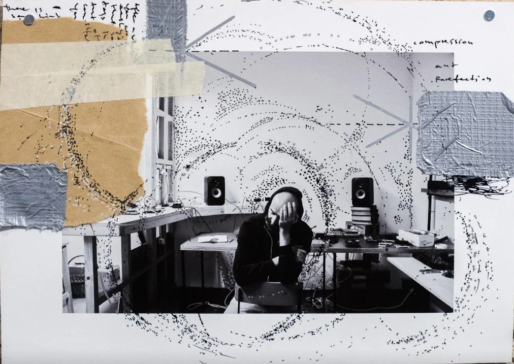 Person in a hoodie working in a cluttered workshop, adjusting audio equipment connected to speakers on a desk.