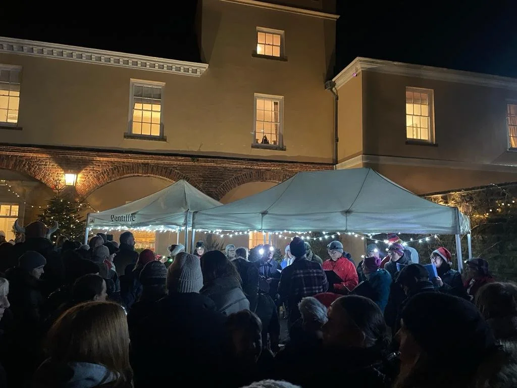 2023_Carols in the courtyard attendees and choir mid shot.jpg